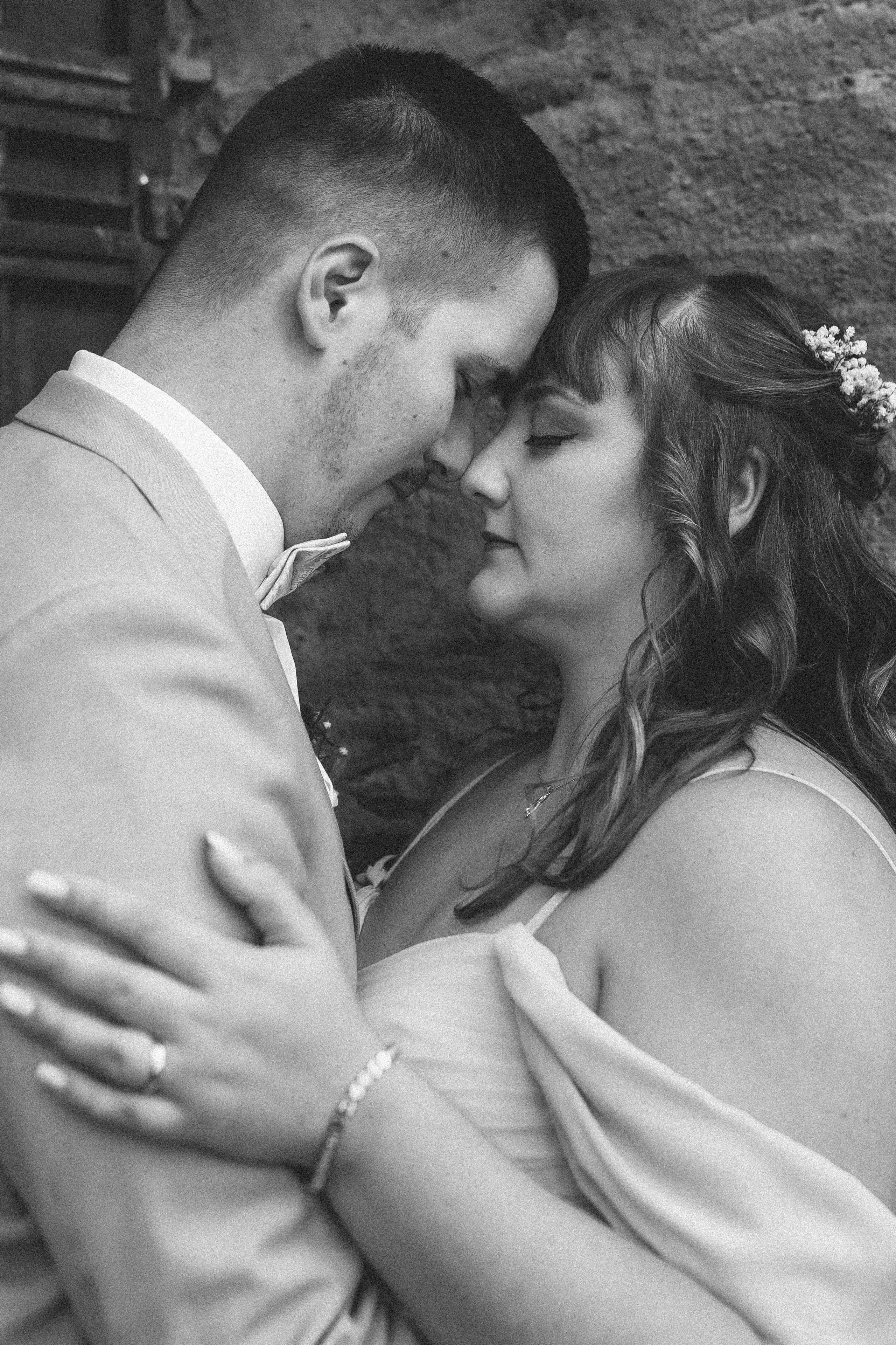 Zärtlicher Moment, in dem sich die Stirnen der Braut und des Bräutigams berühren, ihre Herzen in vollkommenem Einklang.