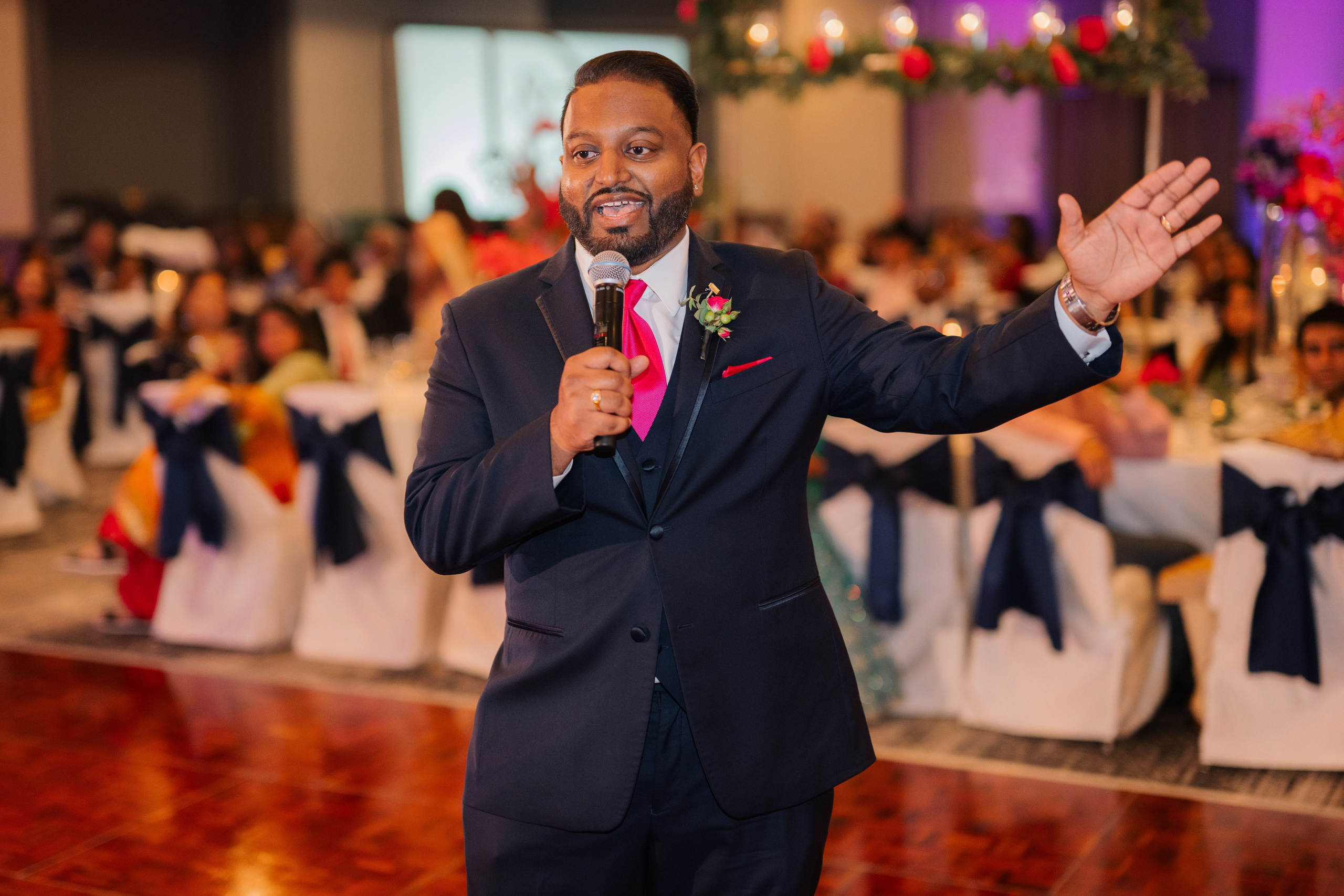 a man in a suit and tie holding a microphone