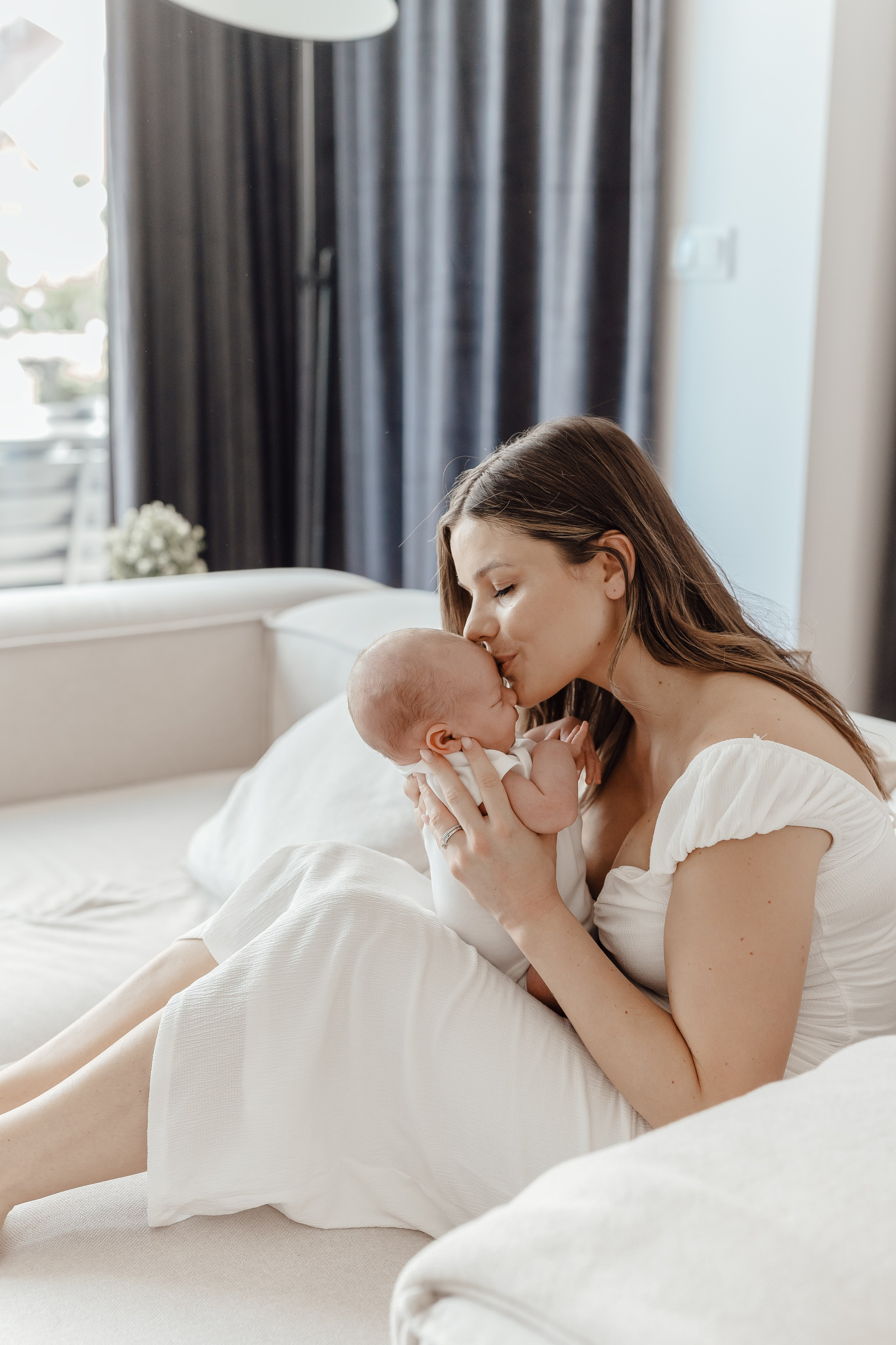 Mama tuląca dziecko w ramionach – fotografia noworodkowa Łódź