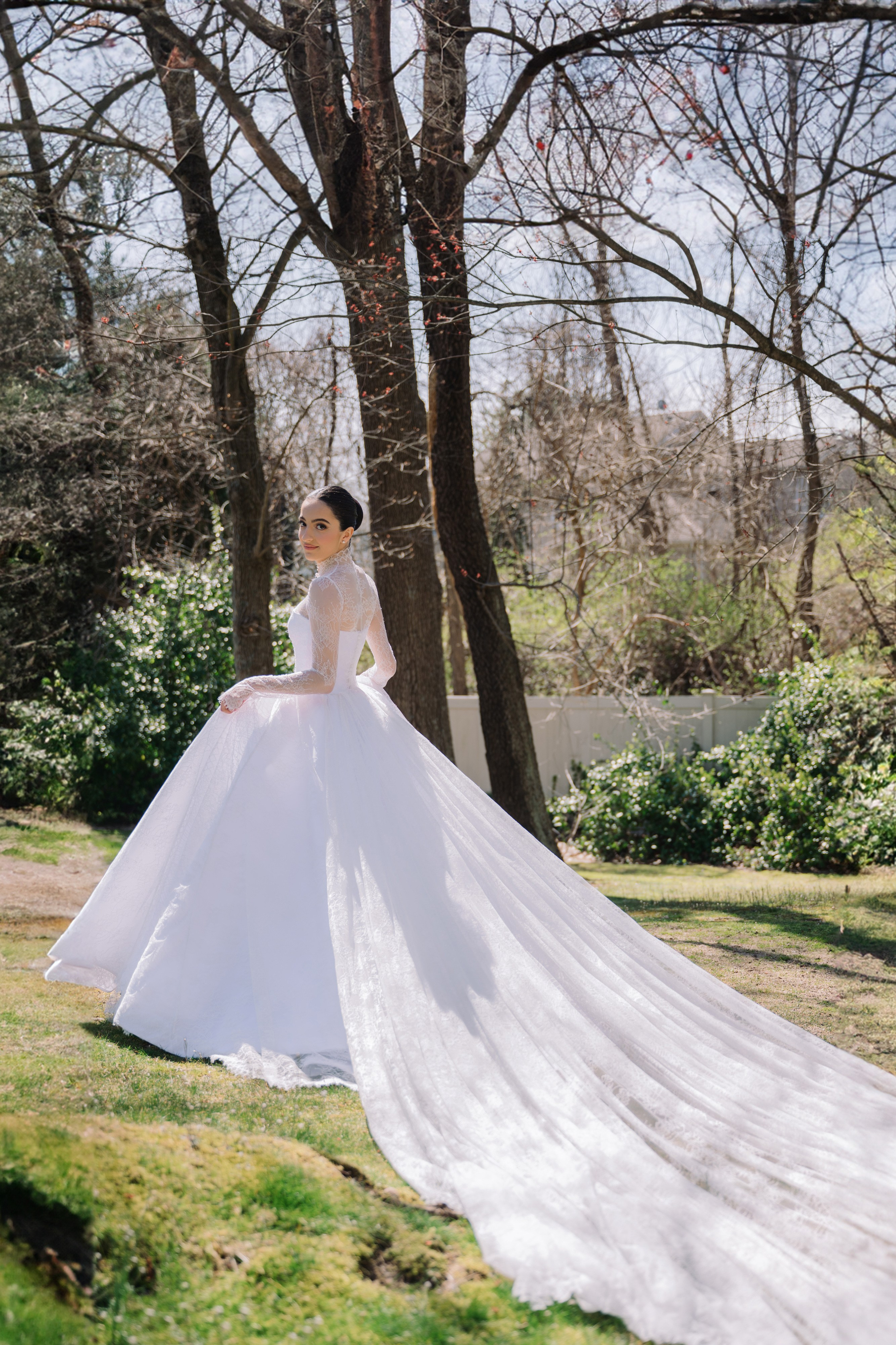 a bride in a white wedding dress standing in the grass
