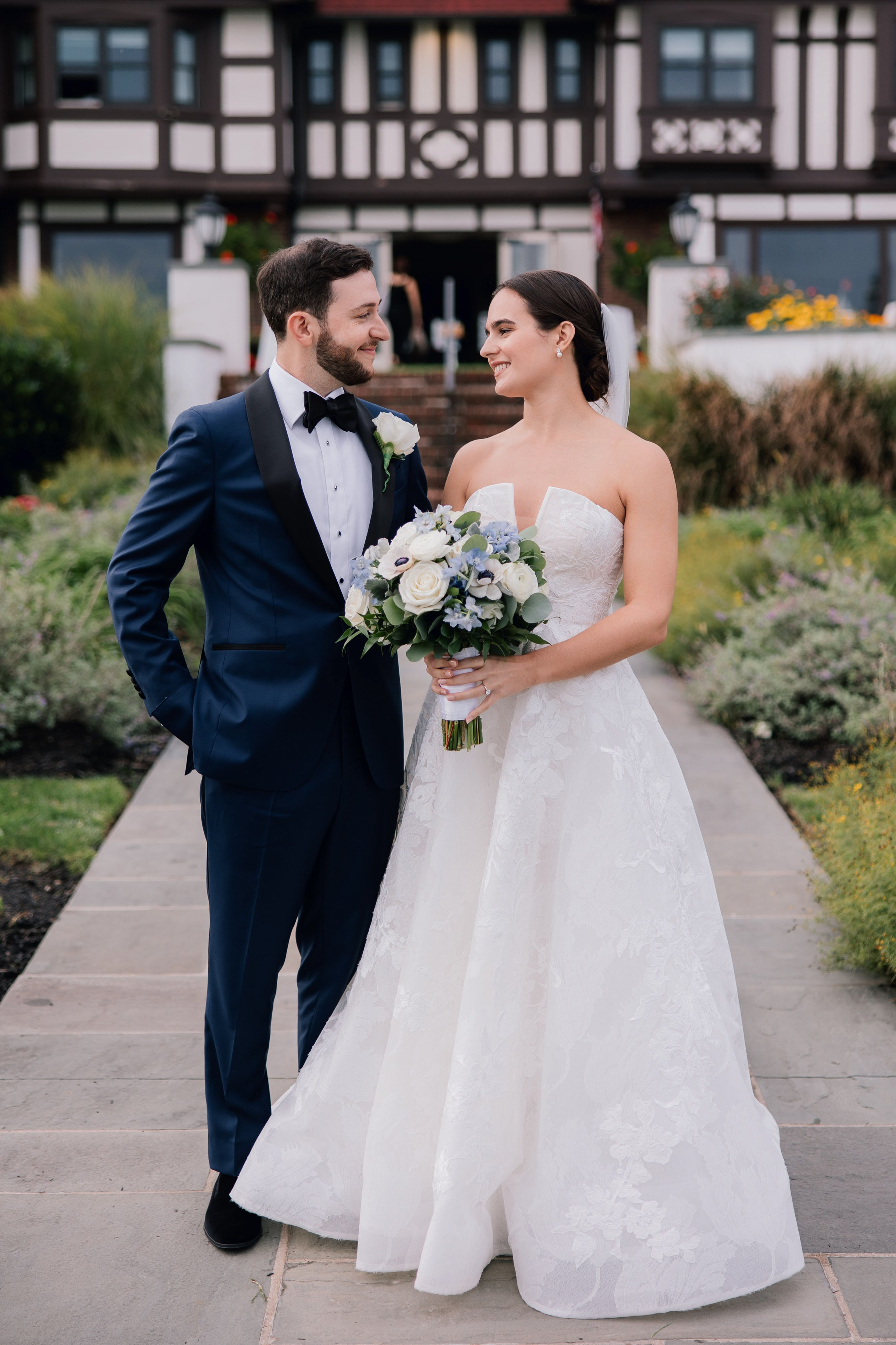 a bride and groom pose for a photo in front of a building