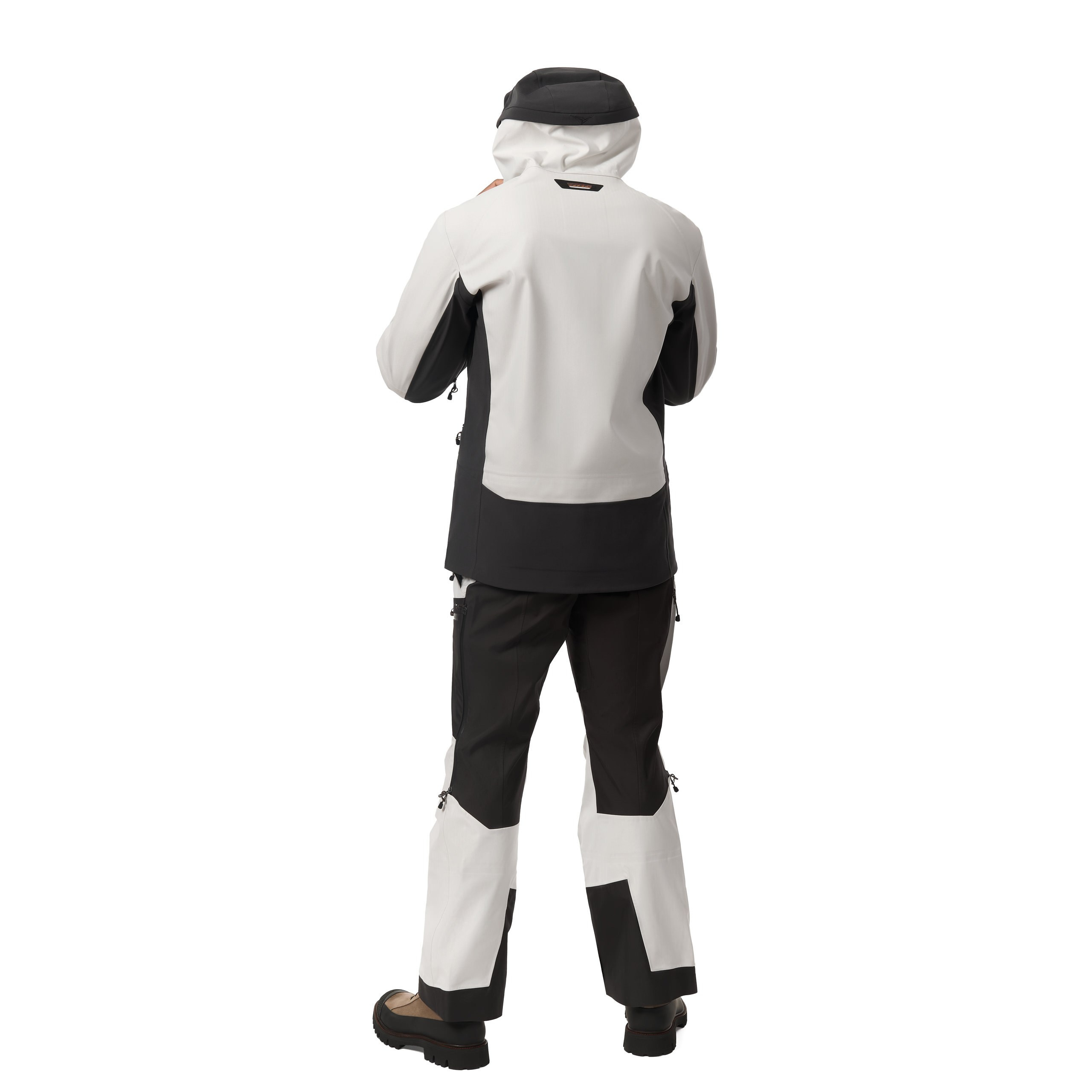 Rückansicht des Models im sportlichen weißen und schwarzen Outfit, Studioaufnahme.