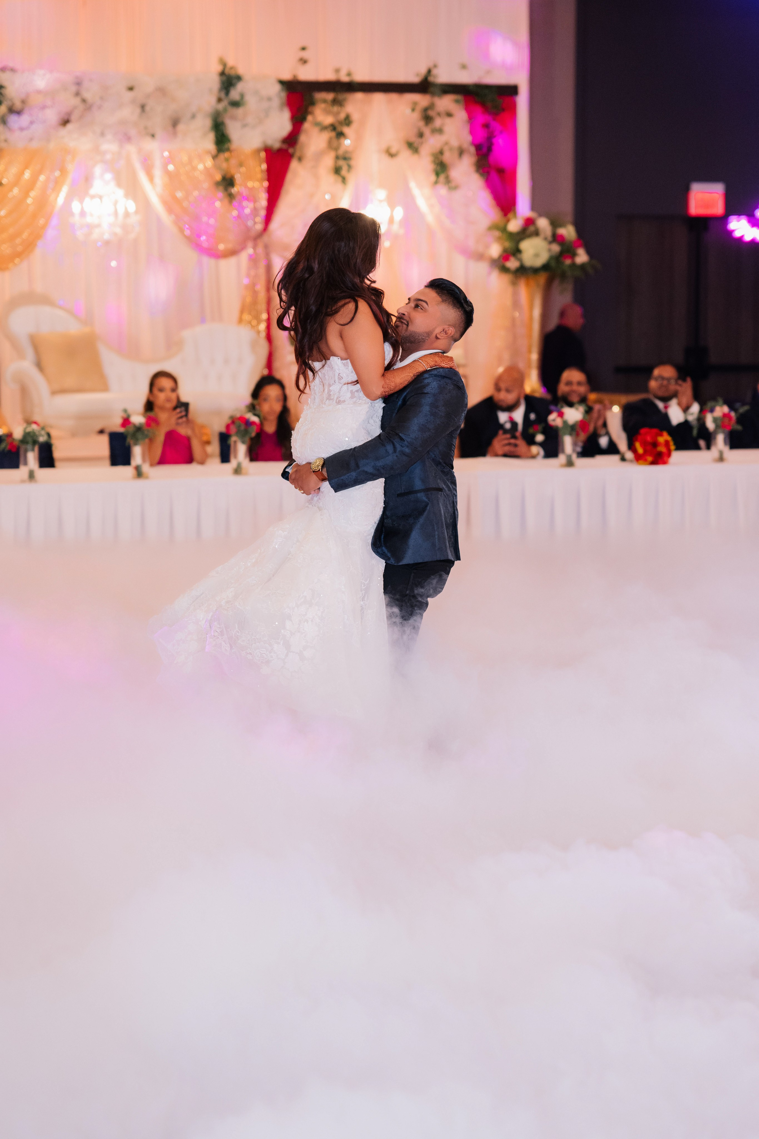 a bride and groom dance in the clouds