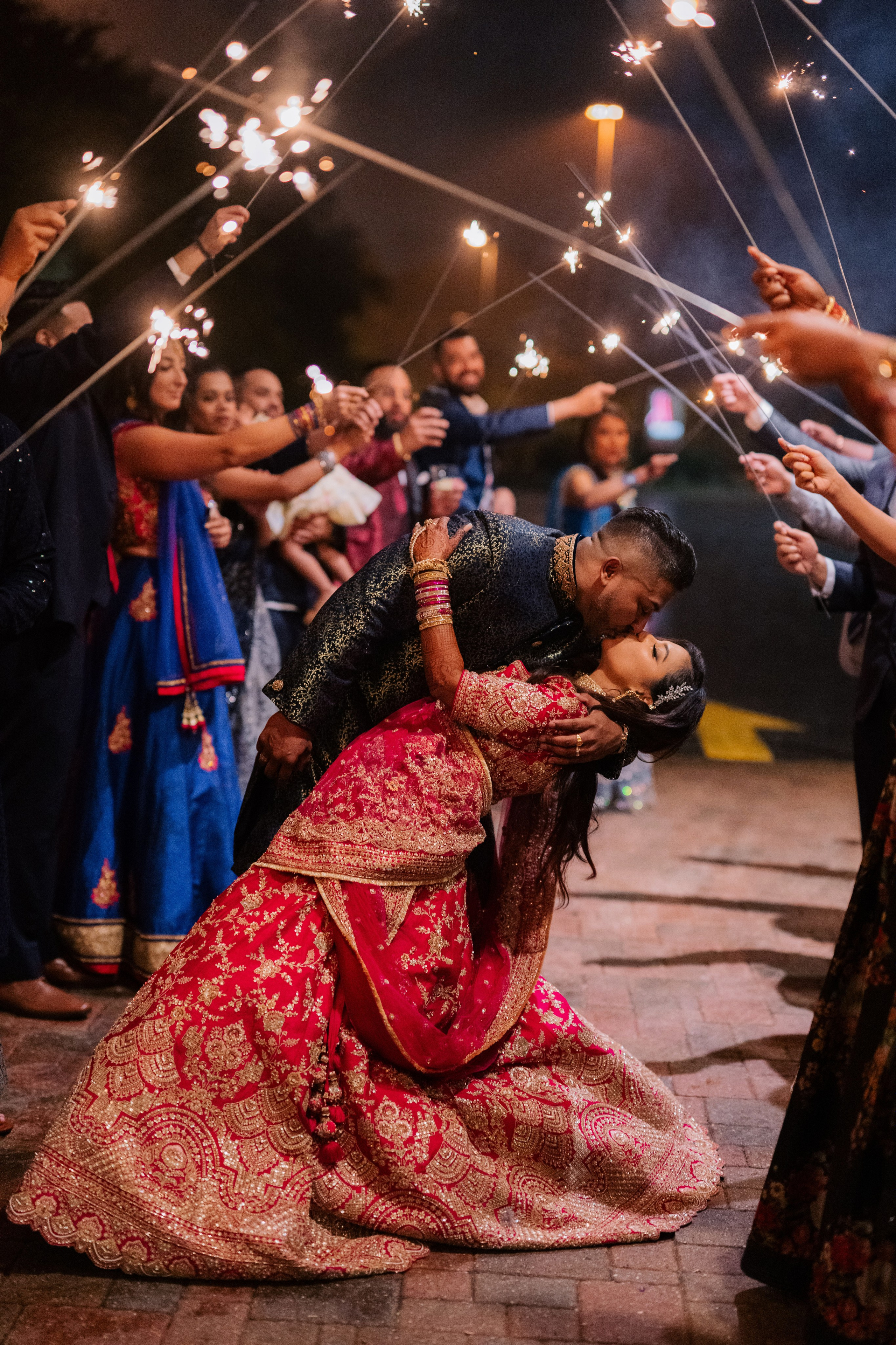 a couple is kissing while holding sparkle sticks