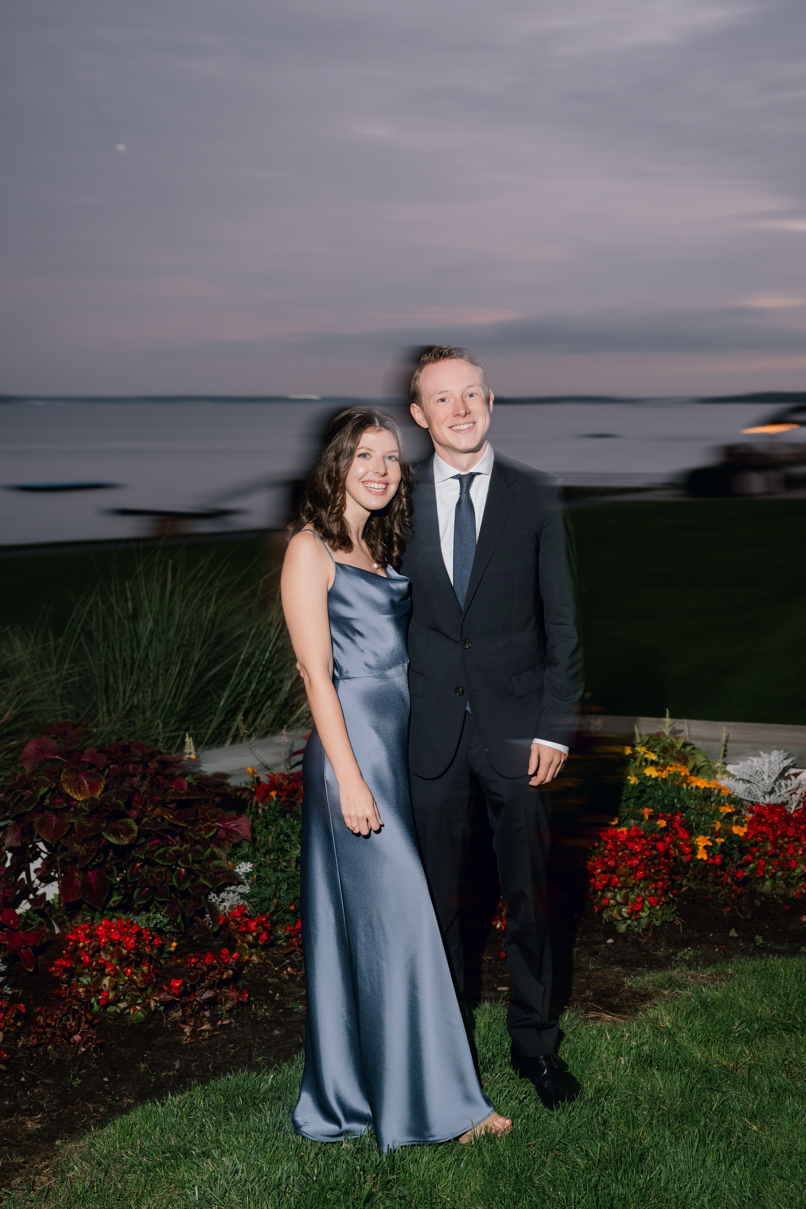 a couple posing for a picture in front of a lake