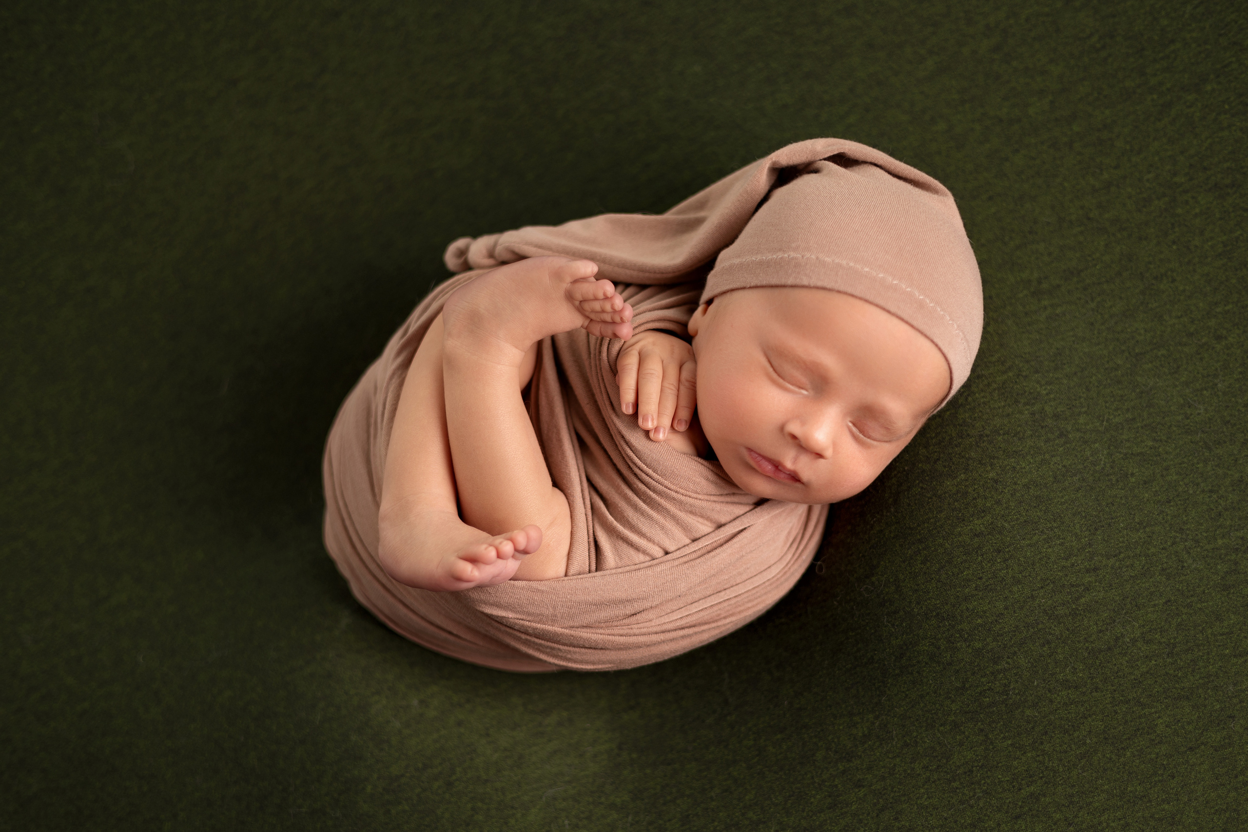 Frisch geborenes Baby eingewickelt in eine Decke, liegt in einem rustikalen Körbchen – Newbornfotografie in Iserlohn