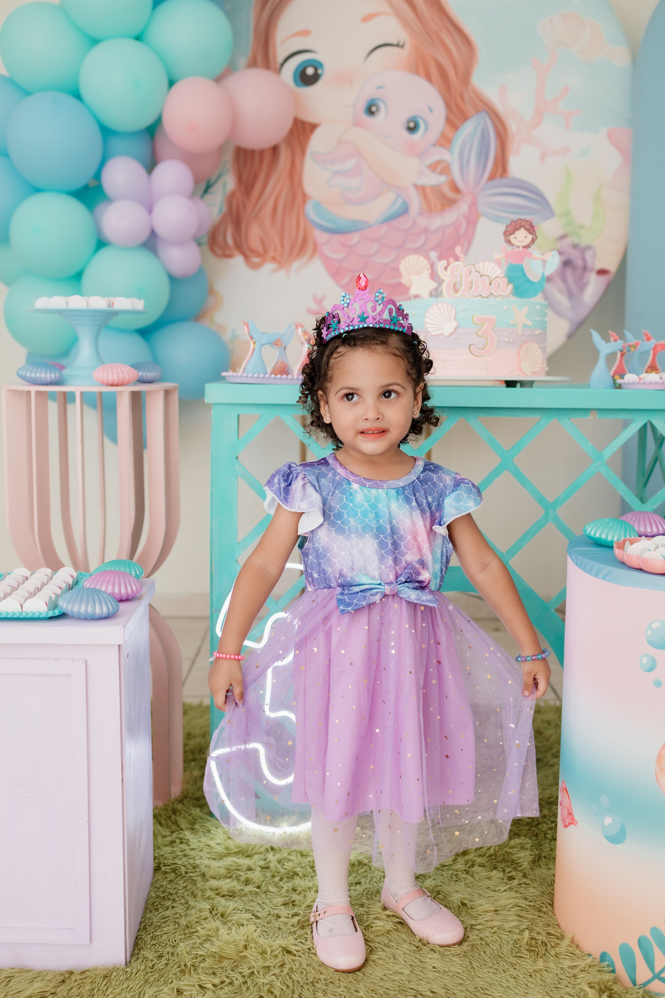 Elisa posando em frente a decoração da festa