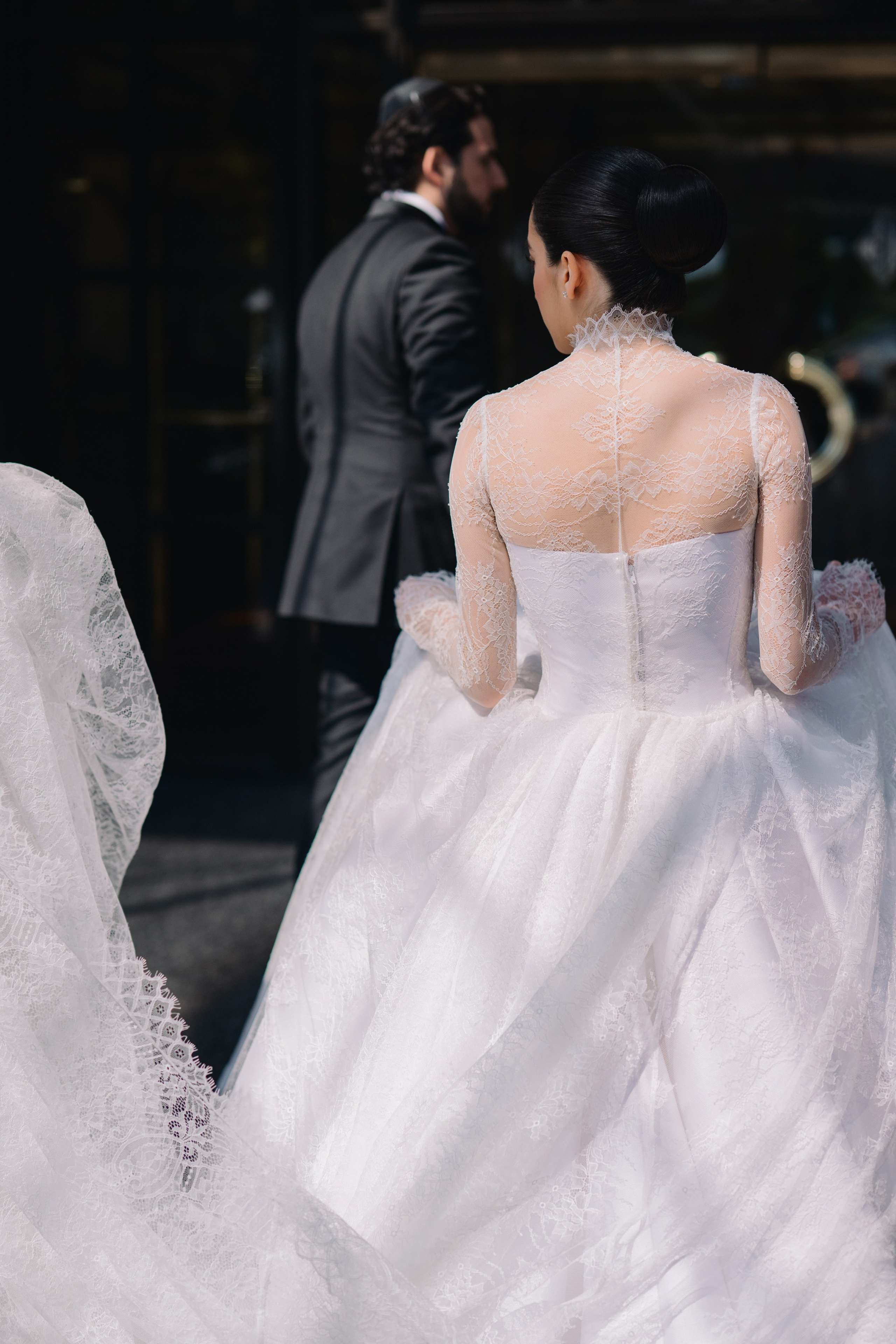 a bride in a white wedding dress is walking down the street