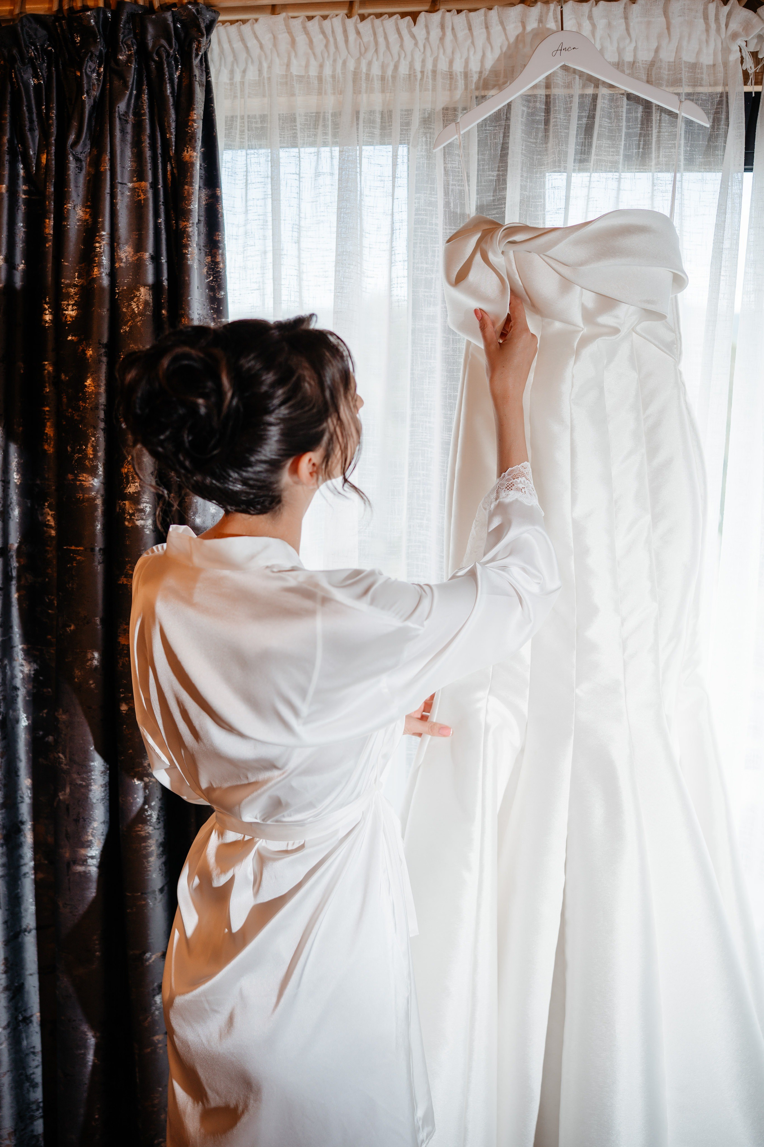 Mireasa admirându-și rochia de nuntă în lumina caldă de la Cabana Masiv.