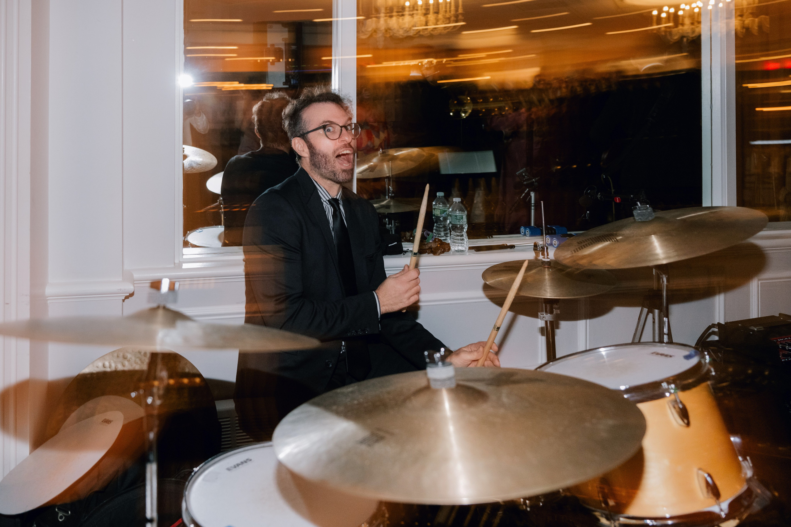 a man in a suit playing drums