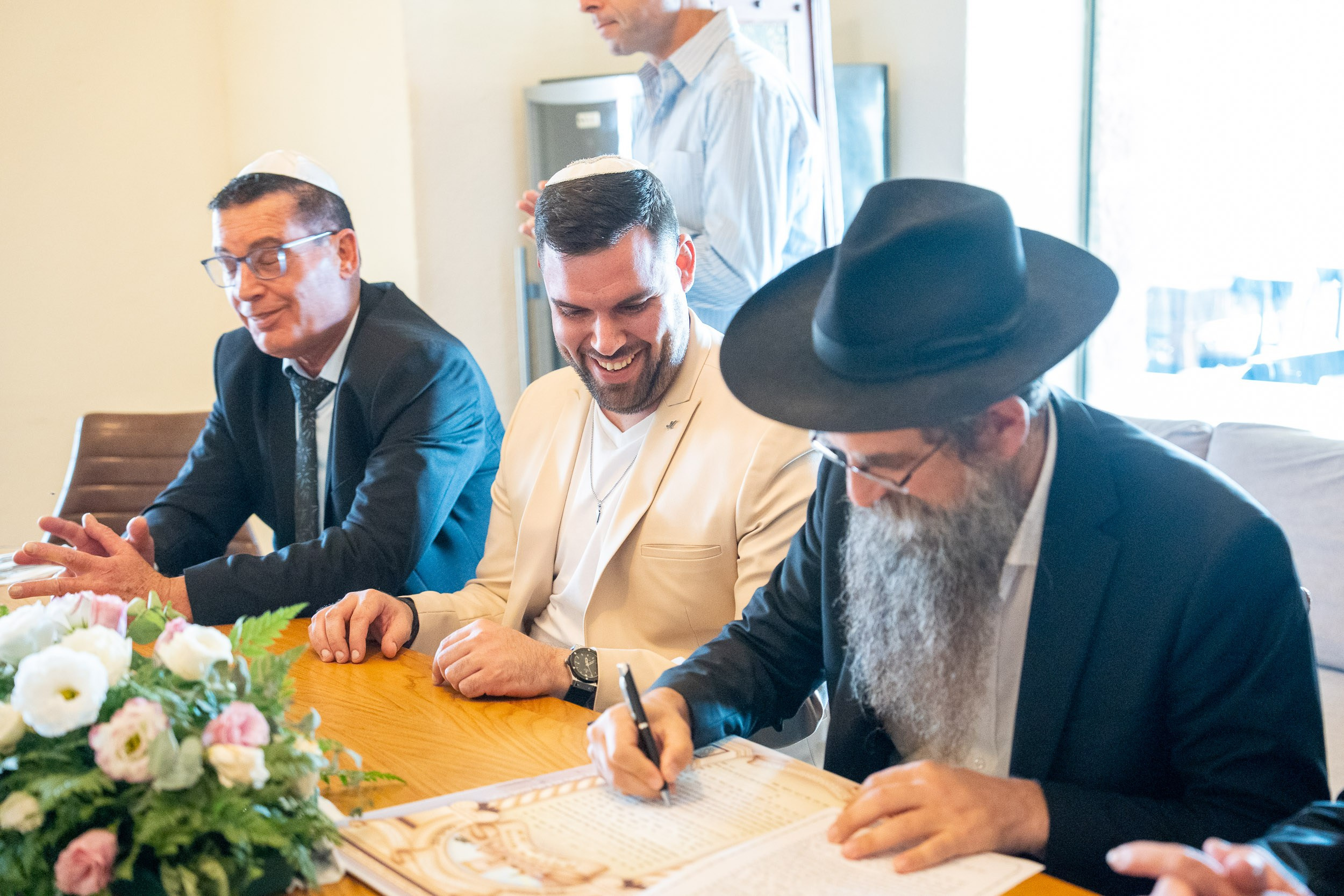 Natanel laughs with the rabbi during the ketubah signing