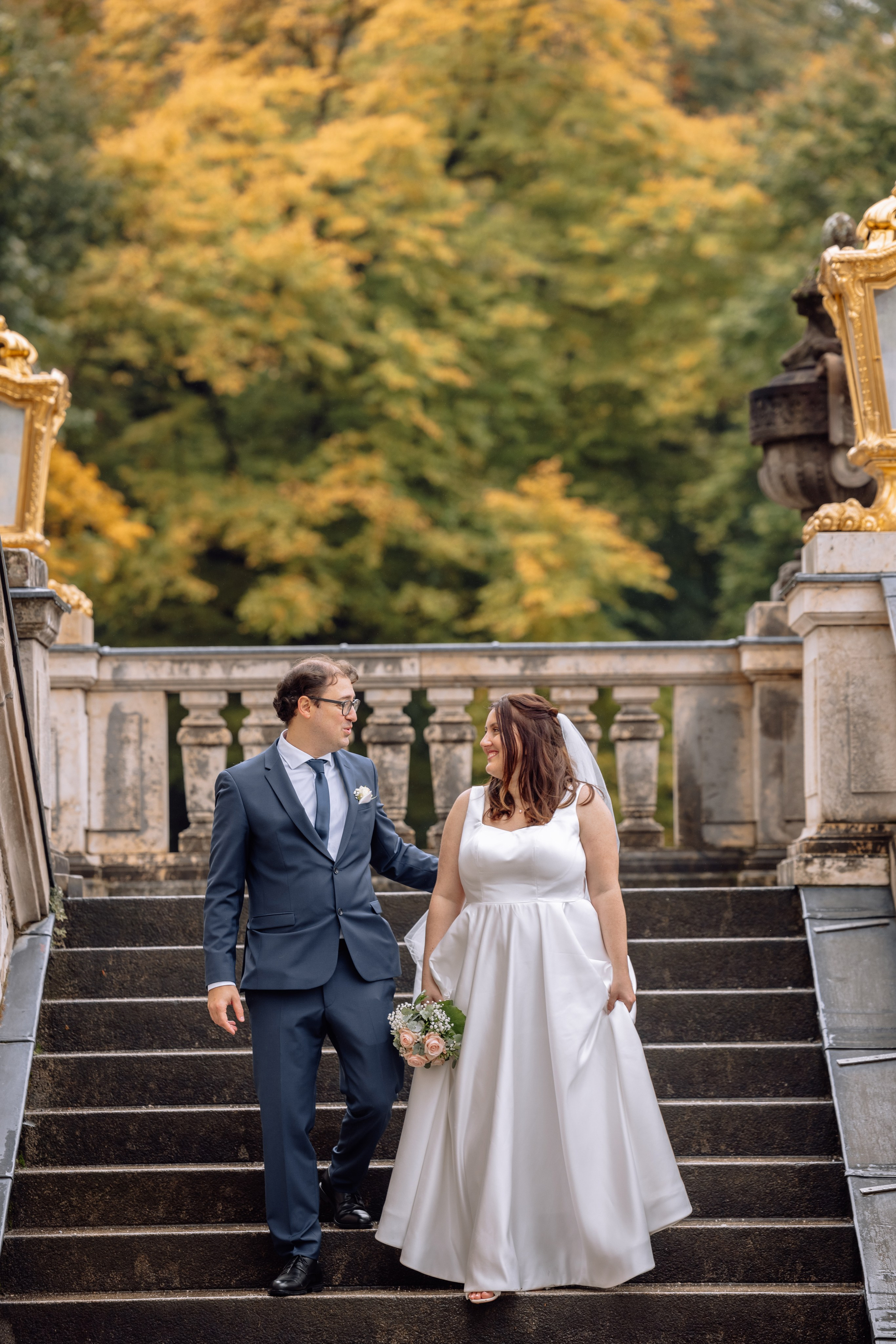 Paar geht erneut die Treppe des Schlosses Nymphenburg in München hinunter