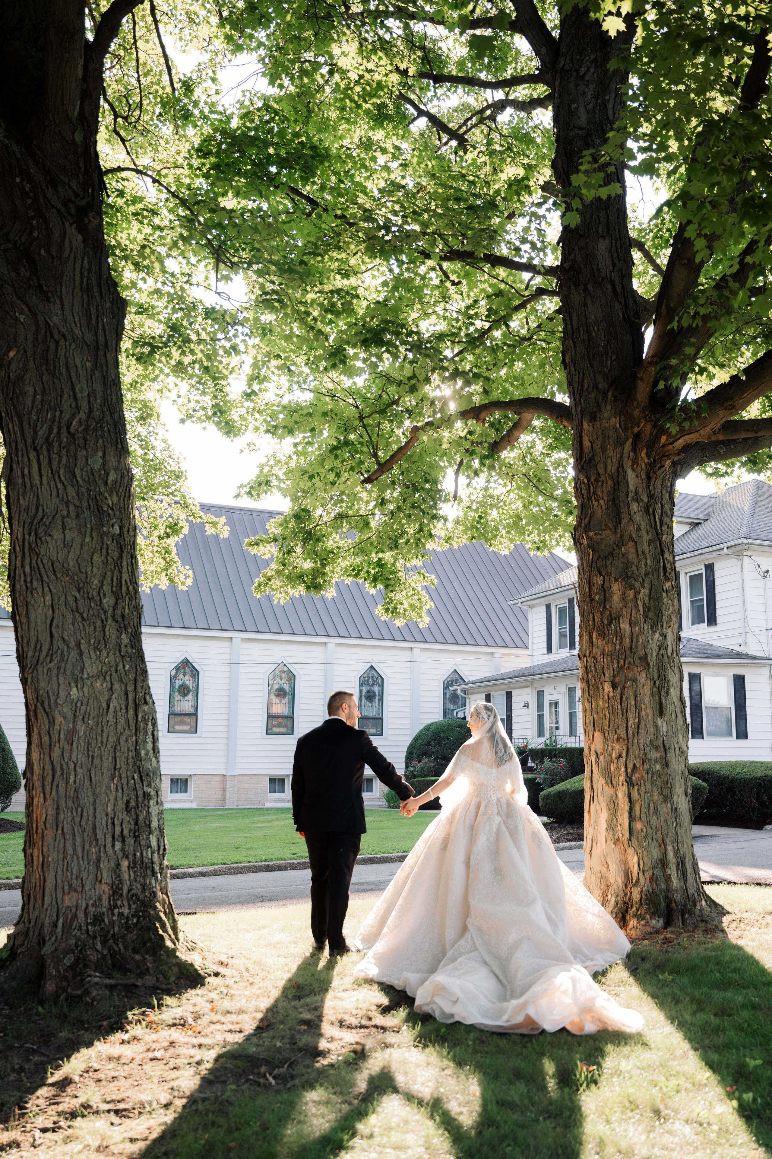 a bride and groom walking through the grass