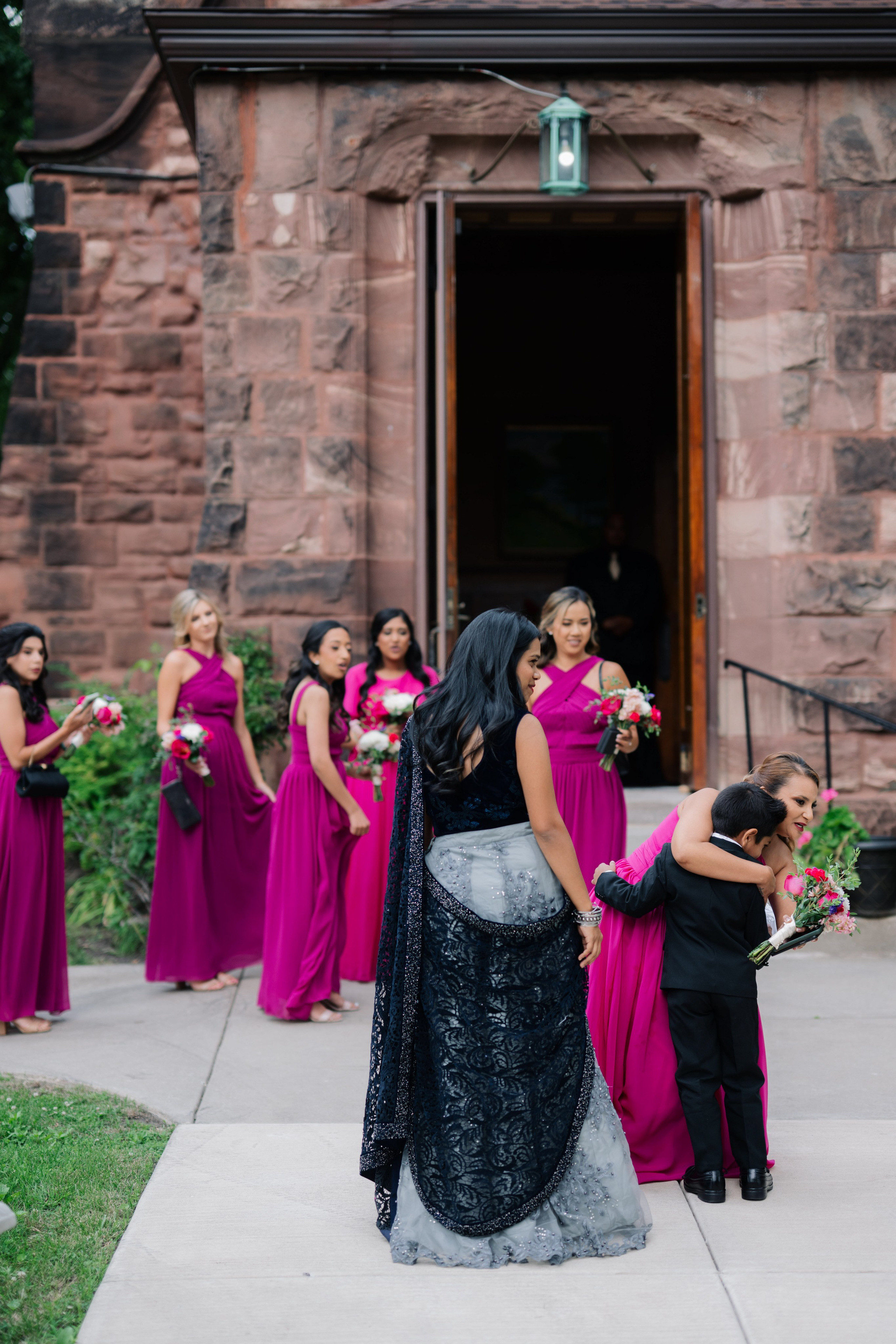 a bridesmaid helping a bridesmaid to get into her dress