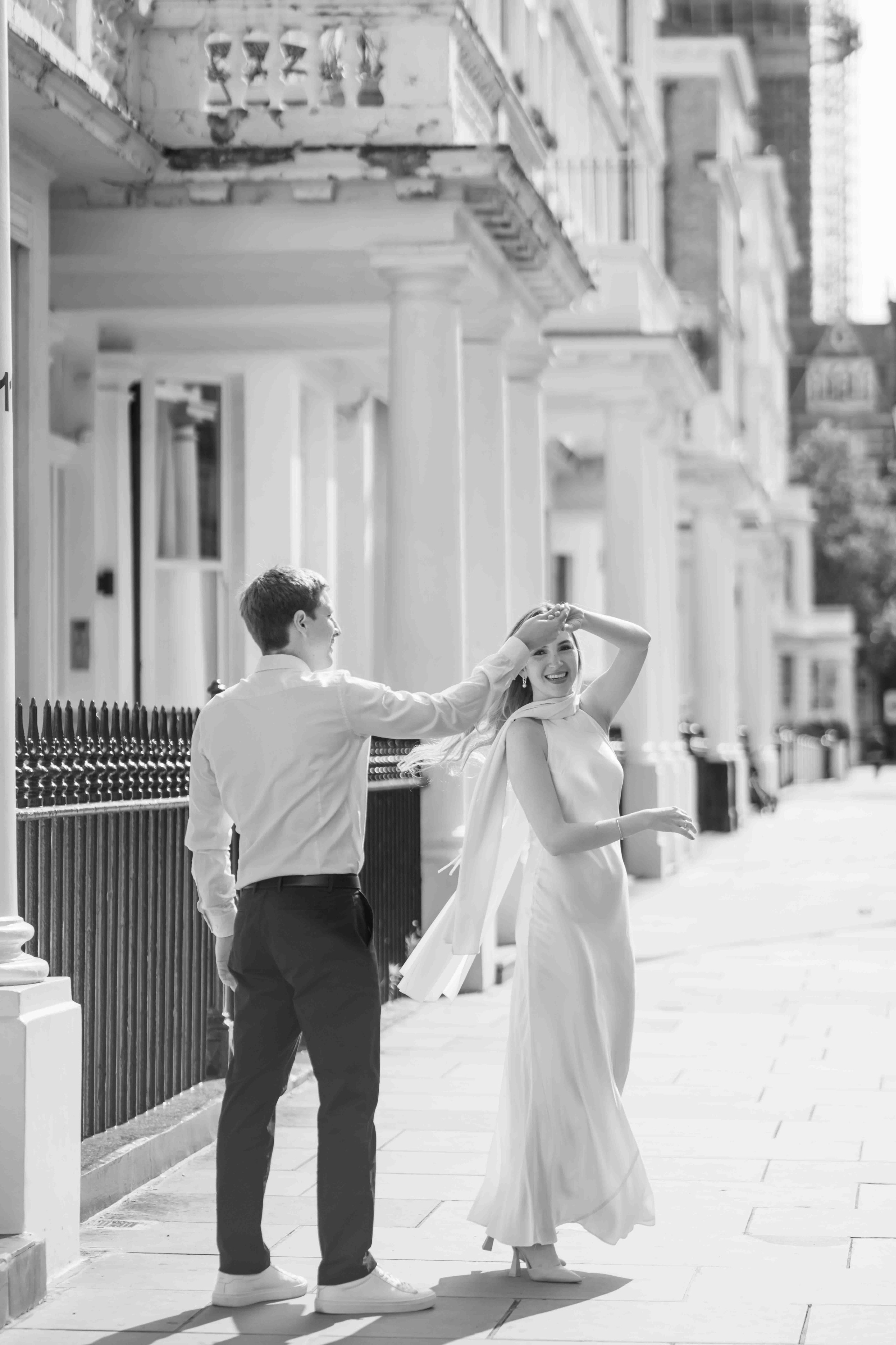 Black and white photo of a couple spinning together in South Kensington London engagement session