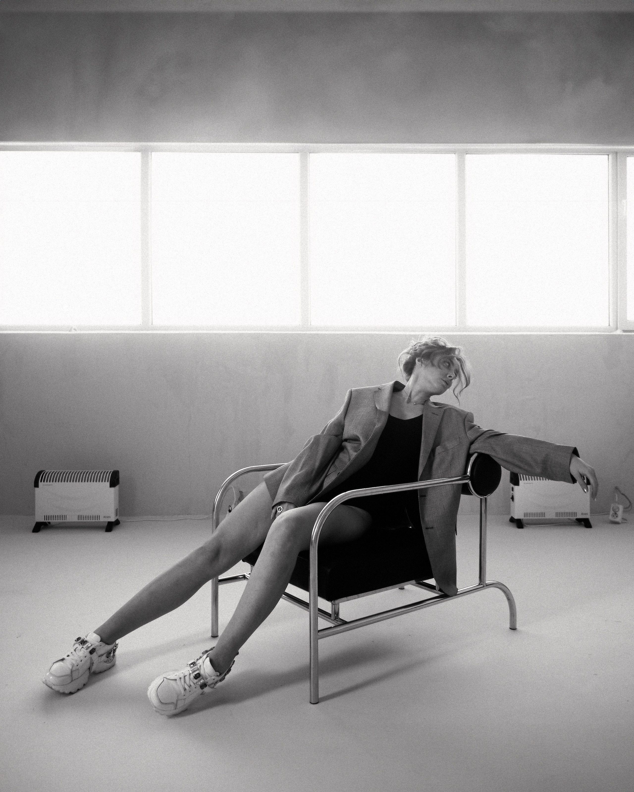 "Черно-белый портрет девушки в мужском пиджаке, задумчиво смотрящей вдаль"