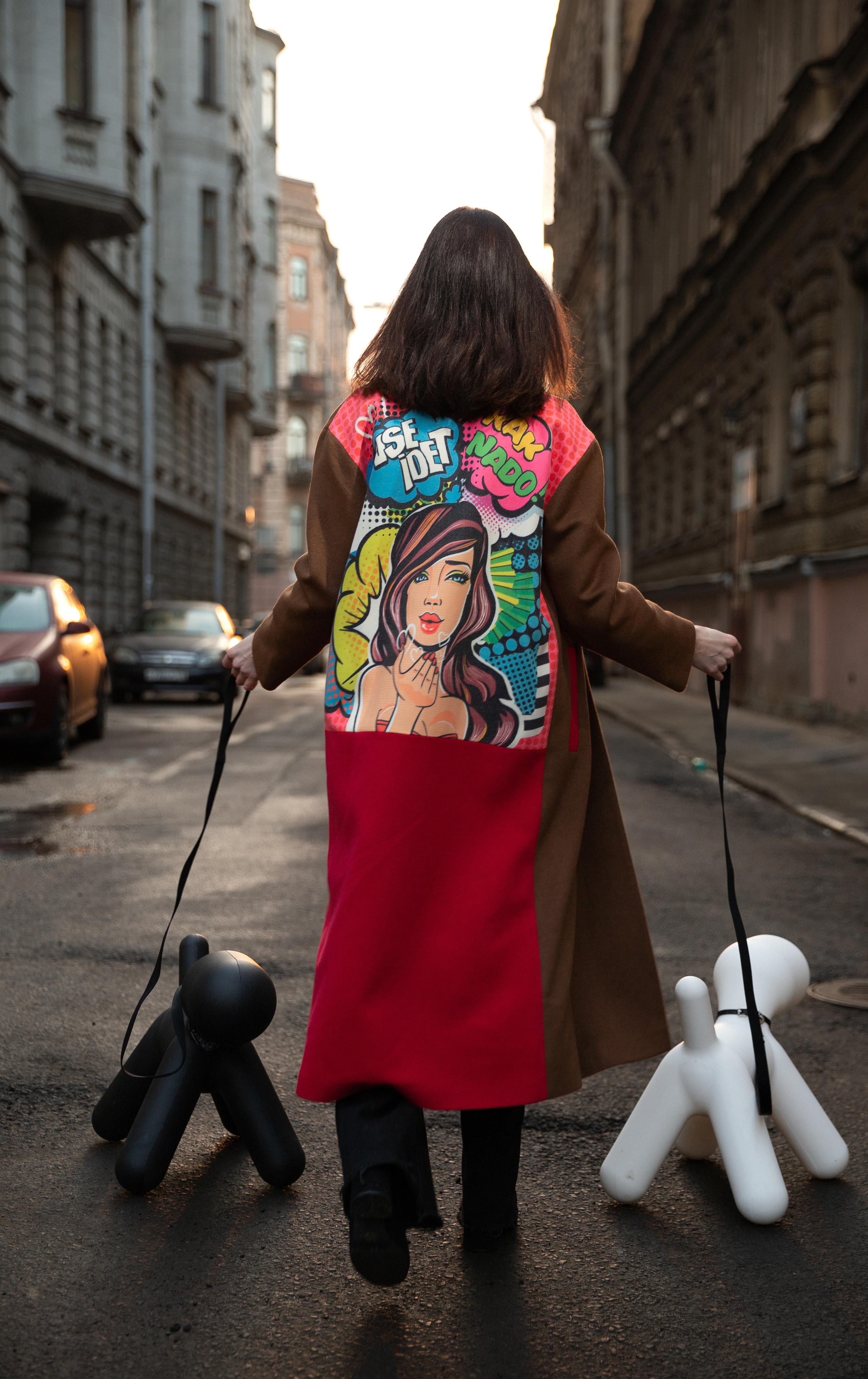 a photo of a girl walking two plastic dogs