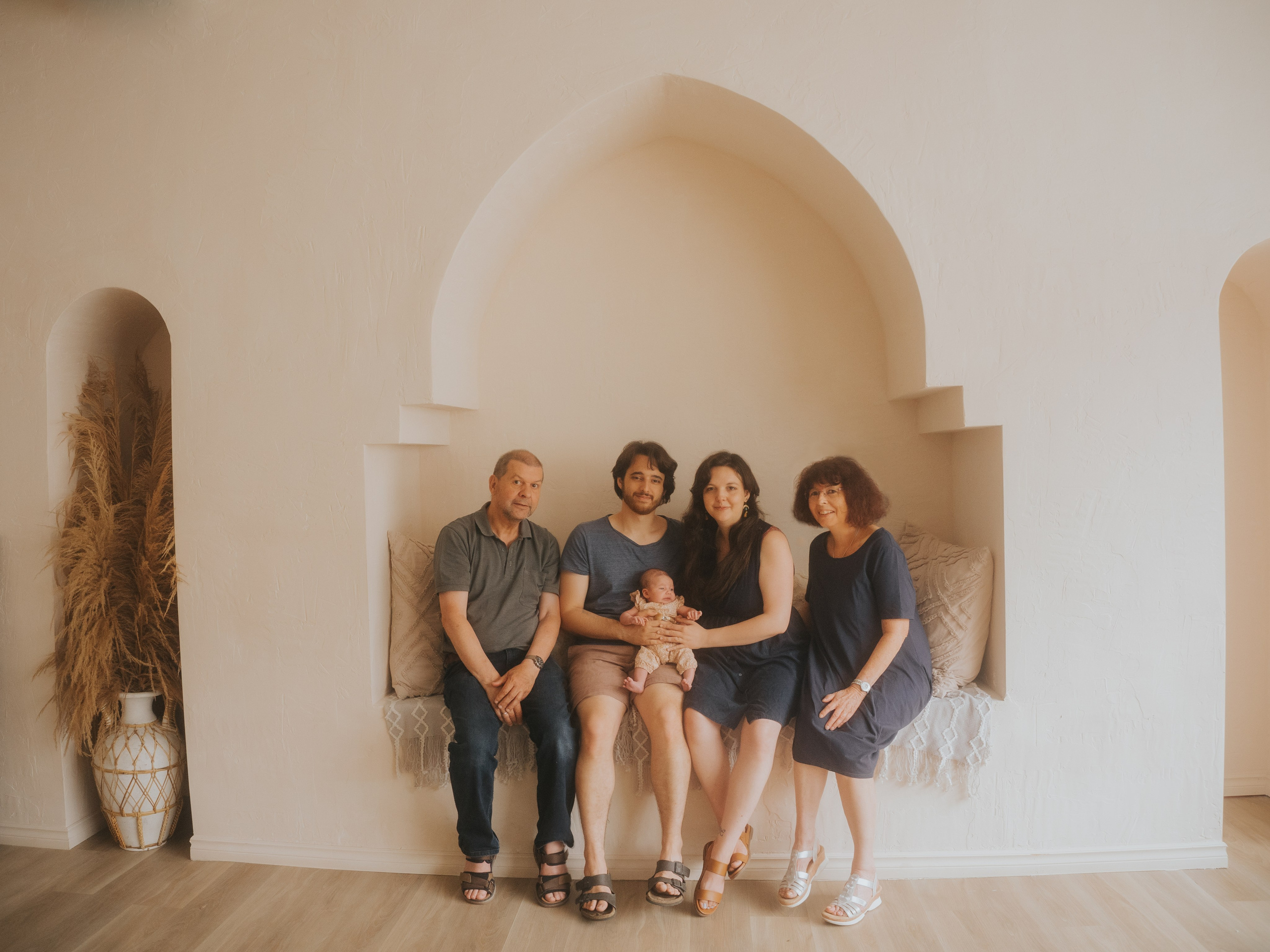 Famille de trois générations en studio entourée d'un arc.