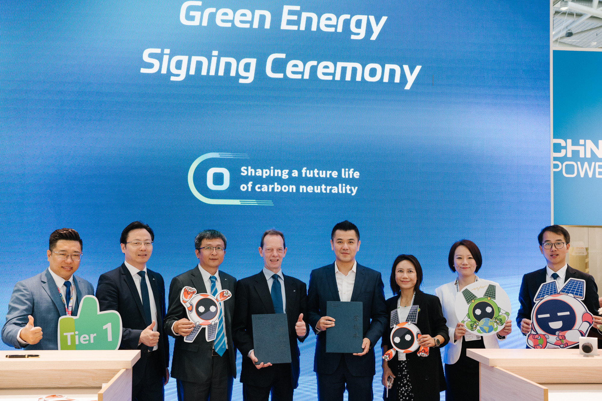 Führungskräfte posieren nach einer Green-Energy-Unterzeichnungszeremonie auf der Messe München