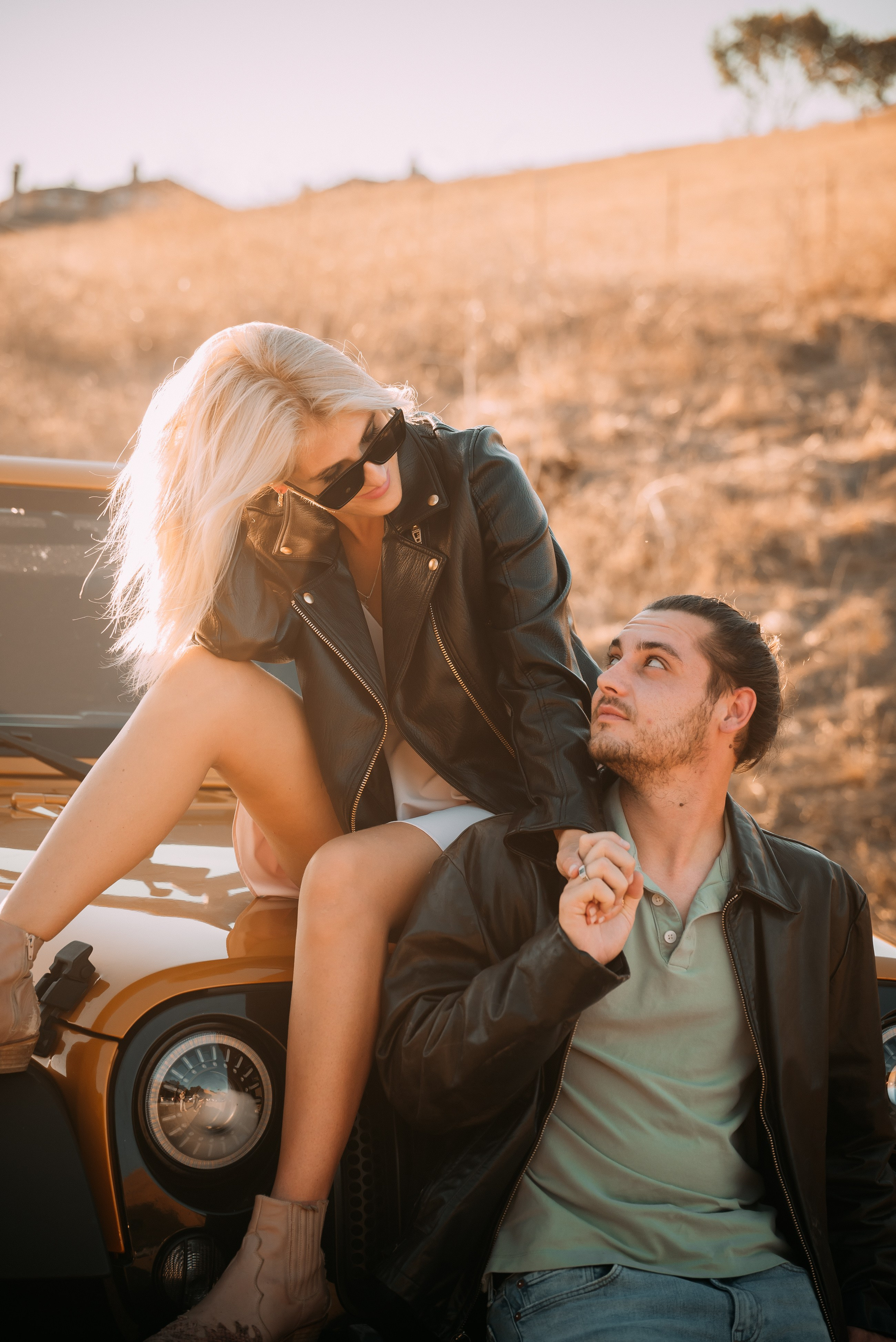 The couple joyfully poses by rugged Jeep, intertwining adventure with a love story.