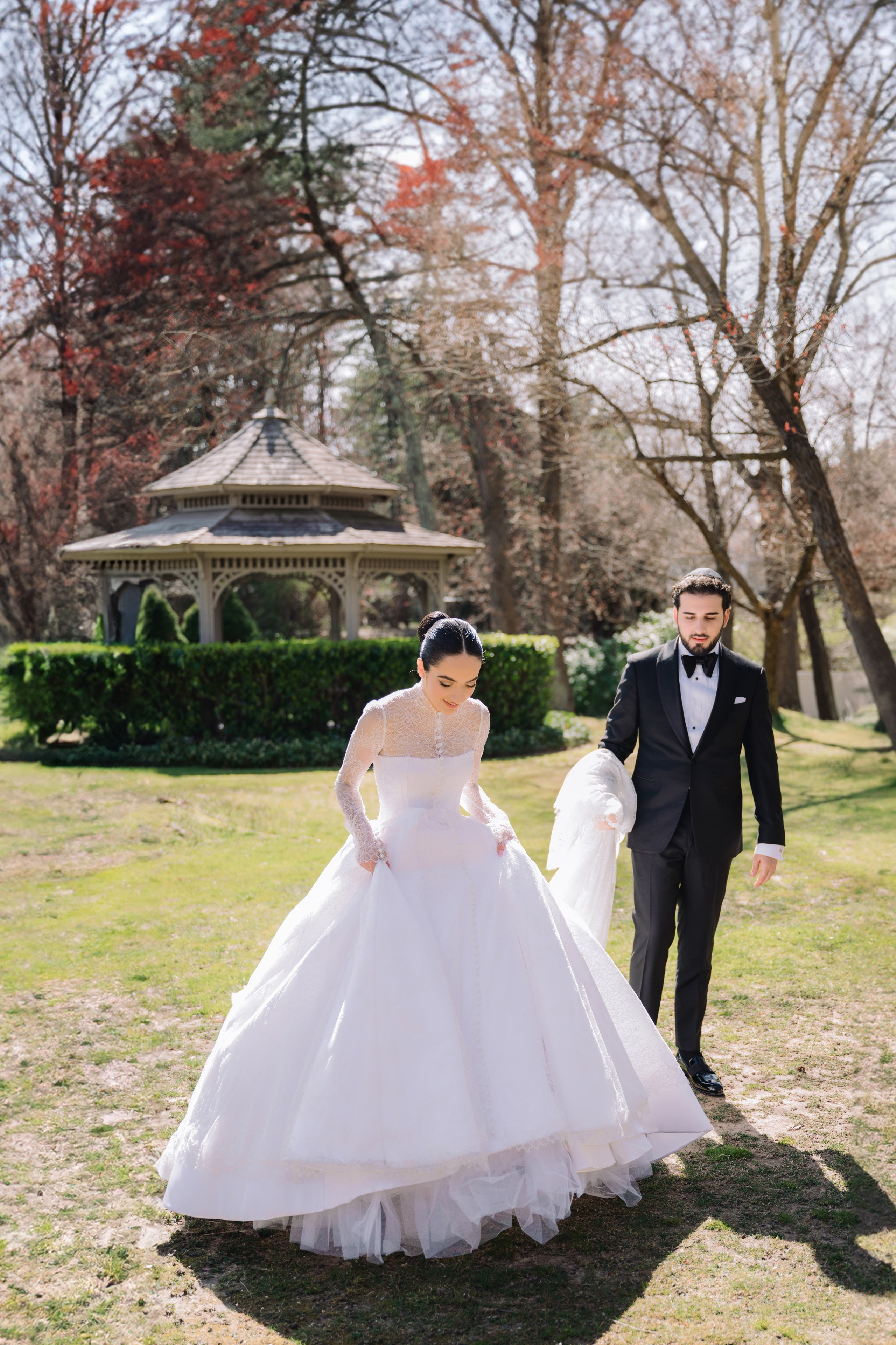 a bride and groom walking through the grass