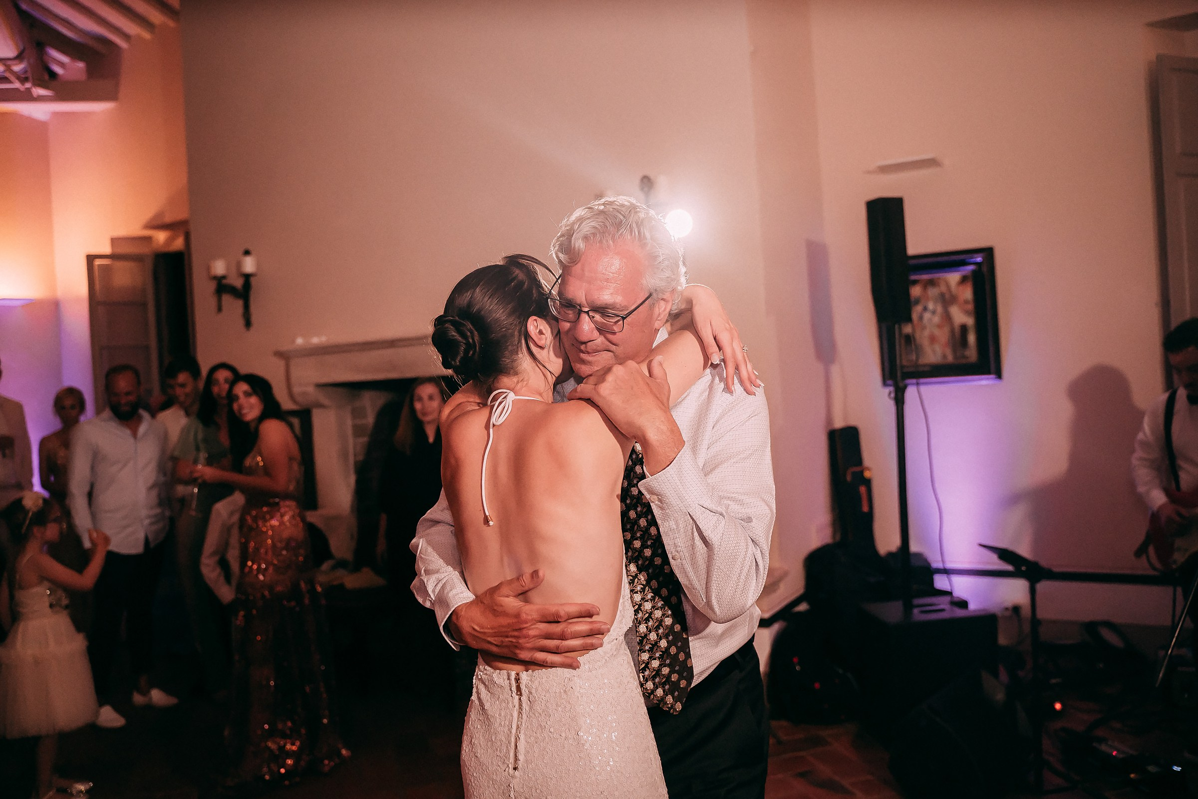 A bride and her father share a touching embrace during their dance, filled with love and emotion.
