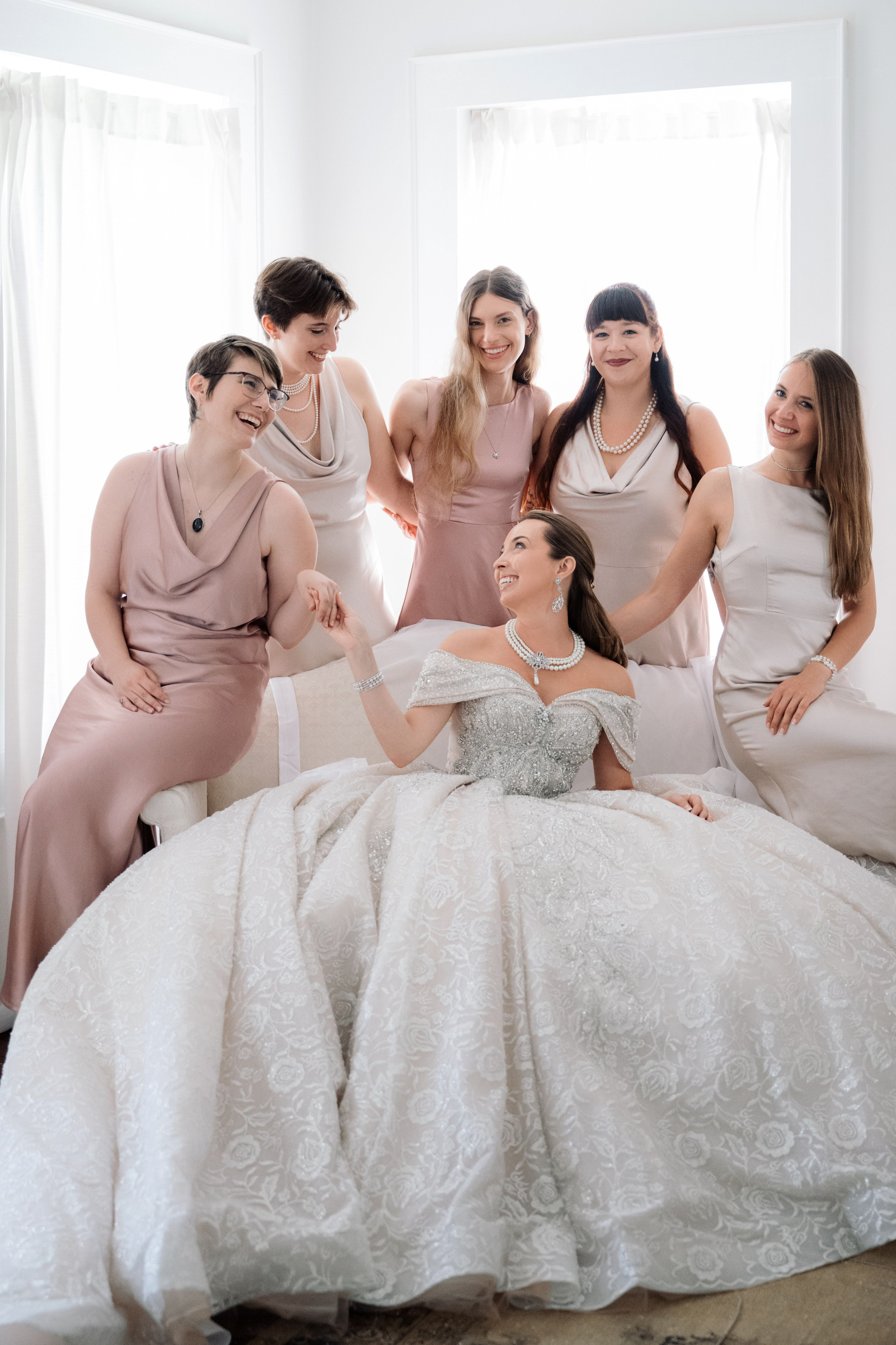 a bride and her bridesmaids in a white room