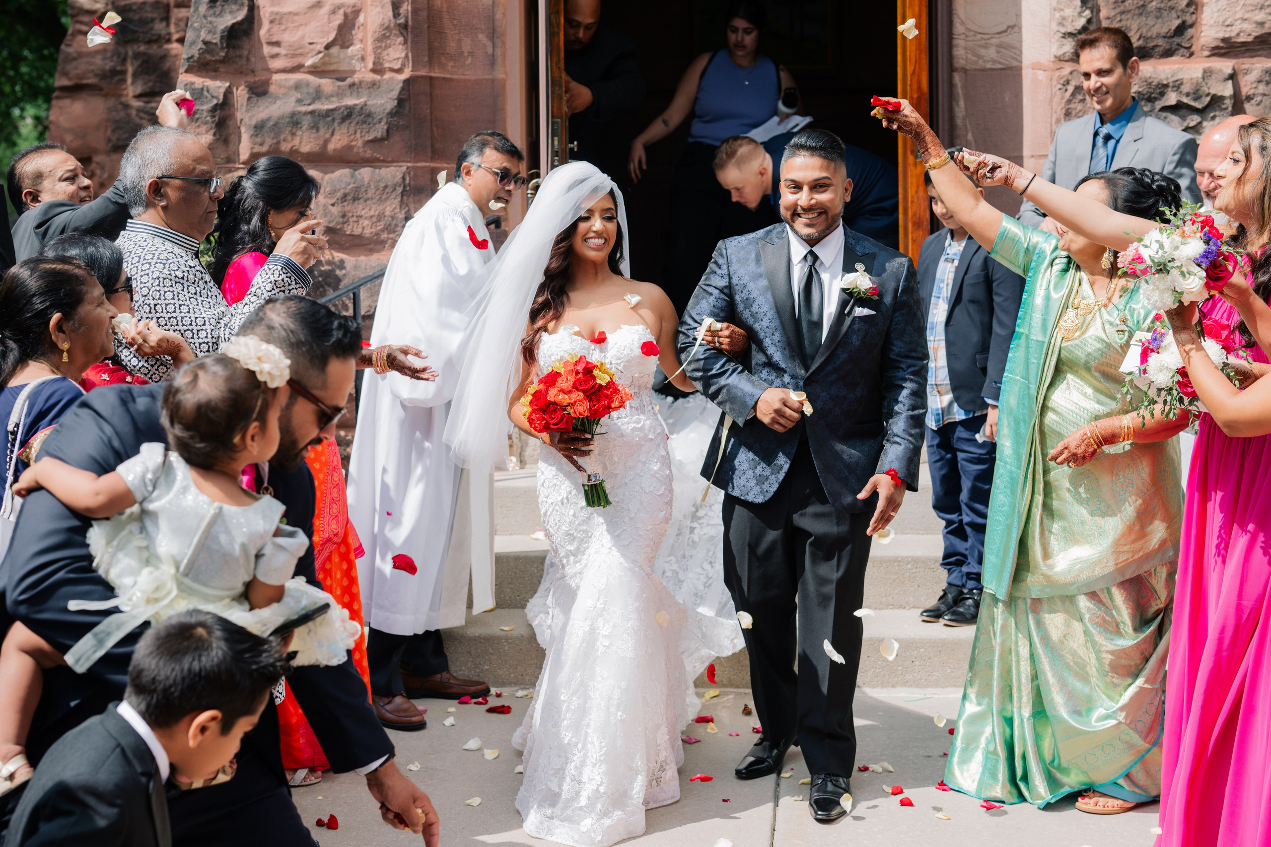 a bride and groom are walking through a crowd of people