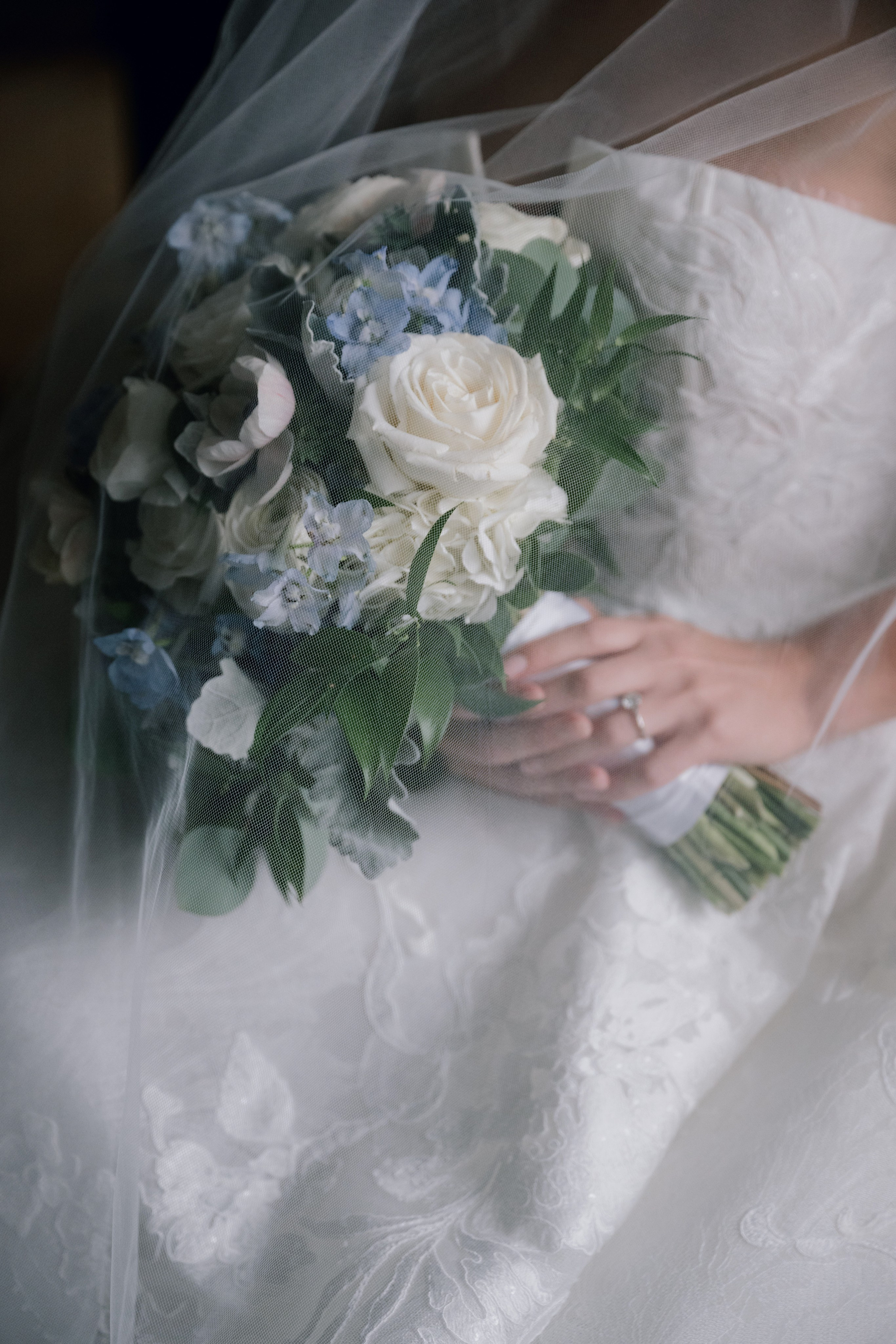 a bride holding a bouquet of white and blue flowers