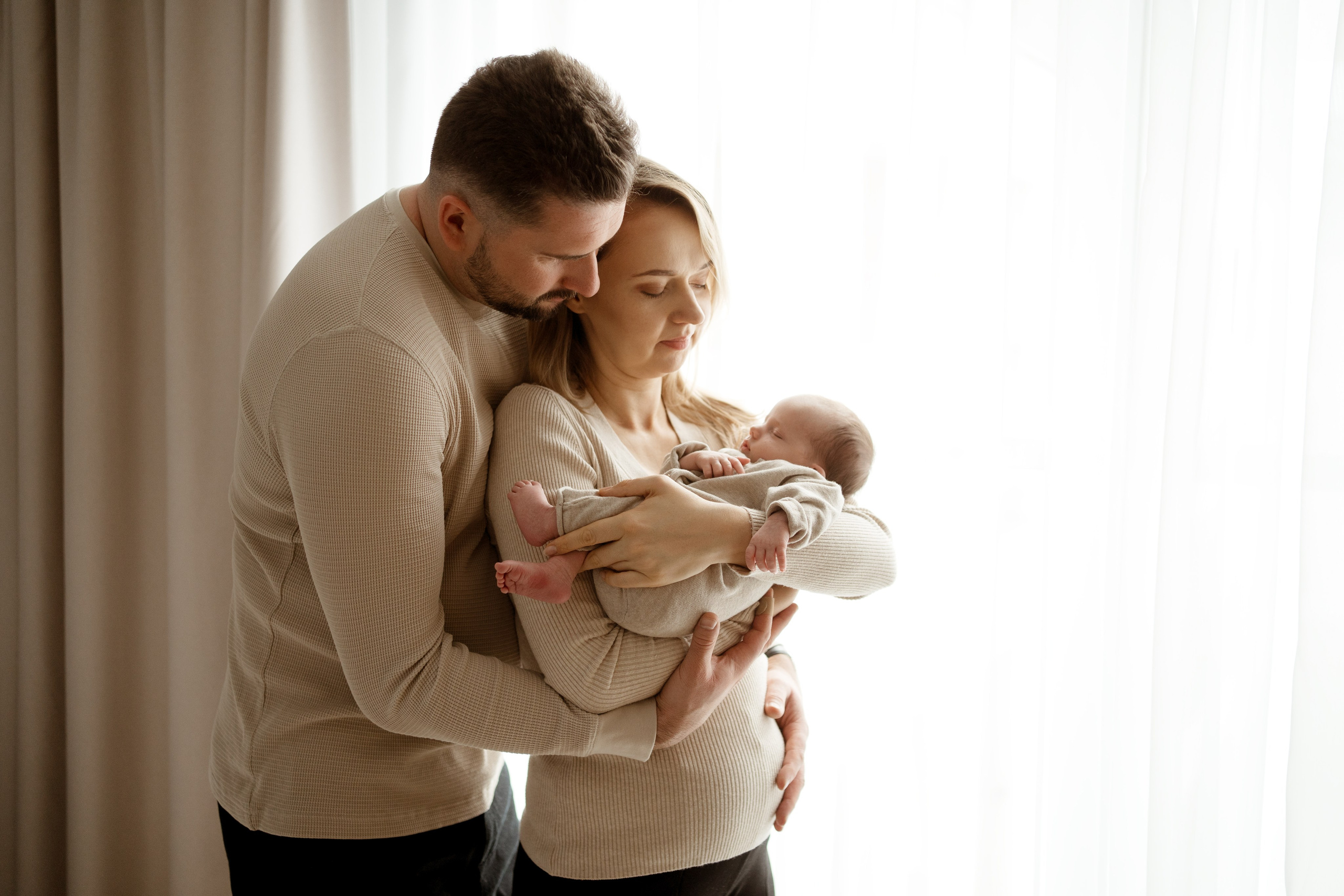 Noworodek owinięty w biały koc – naturalna fotografia w Łodzi