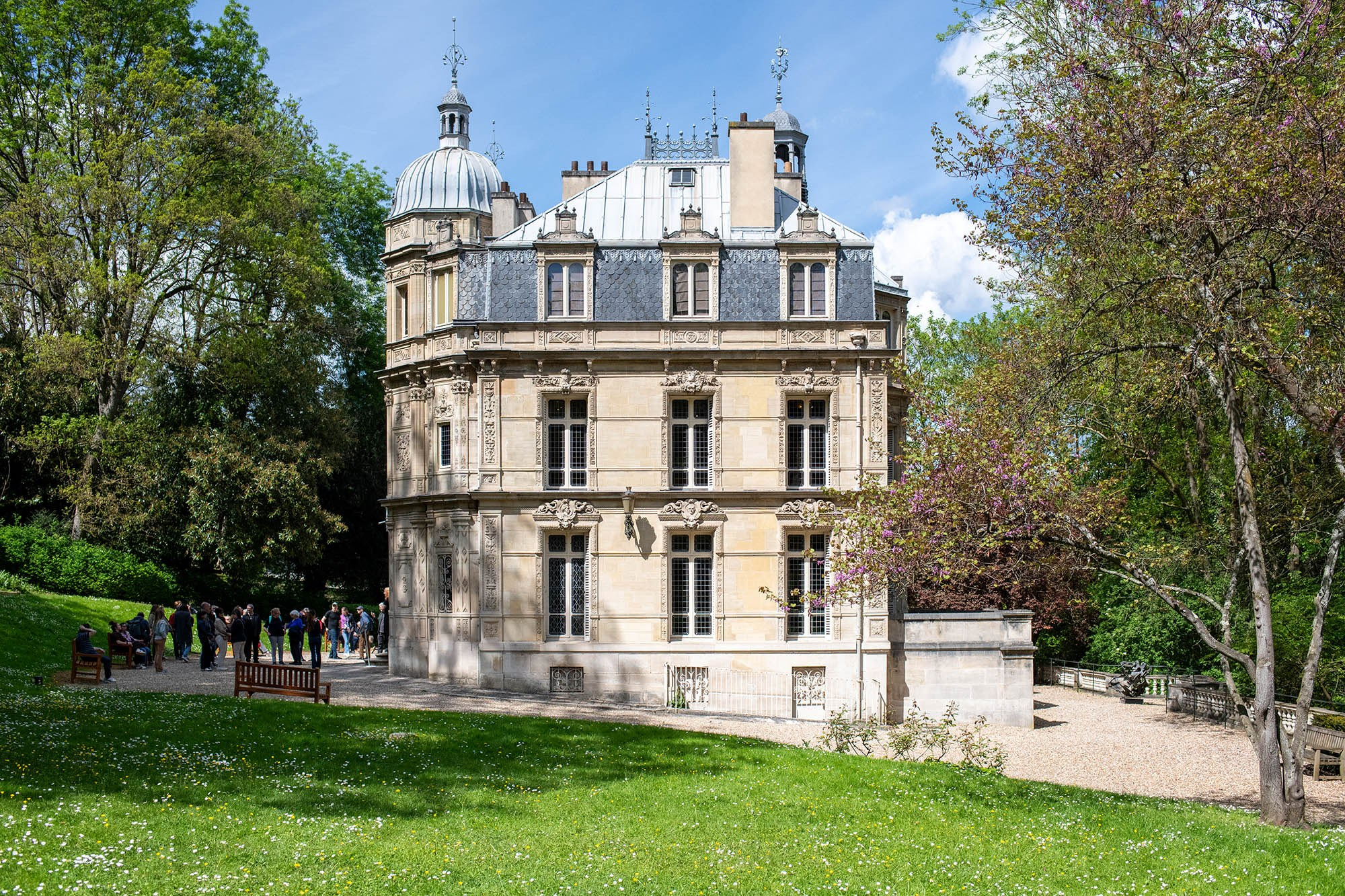 Exterior view of the Château de Monte-Cristo surrounded by gardens and trees near Paris, France.