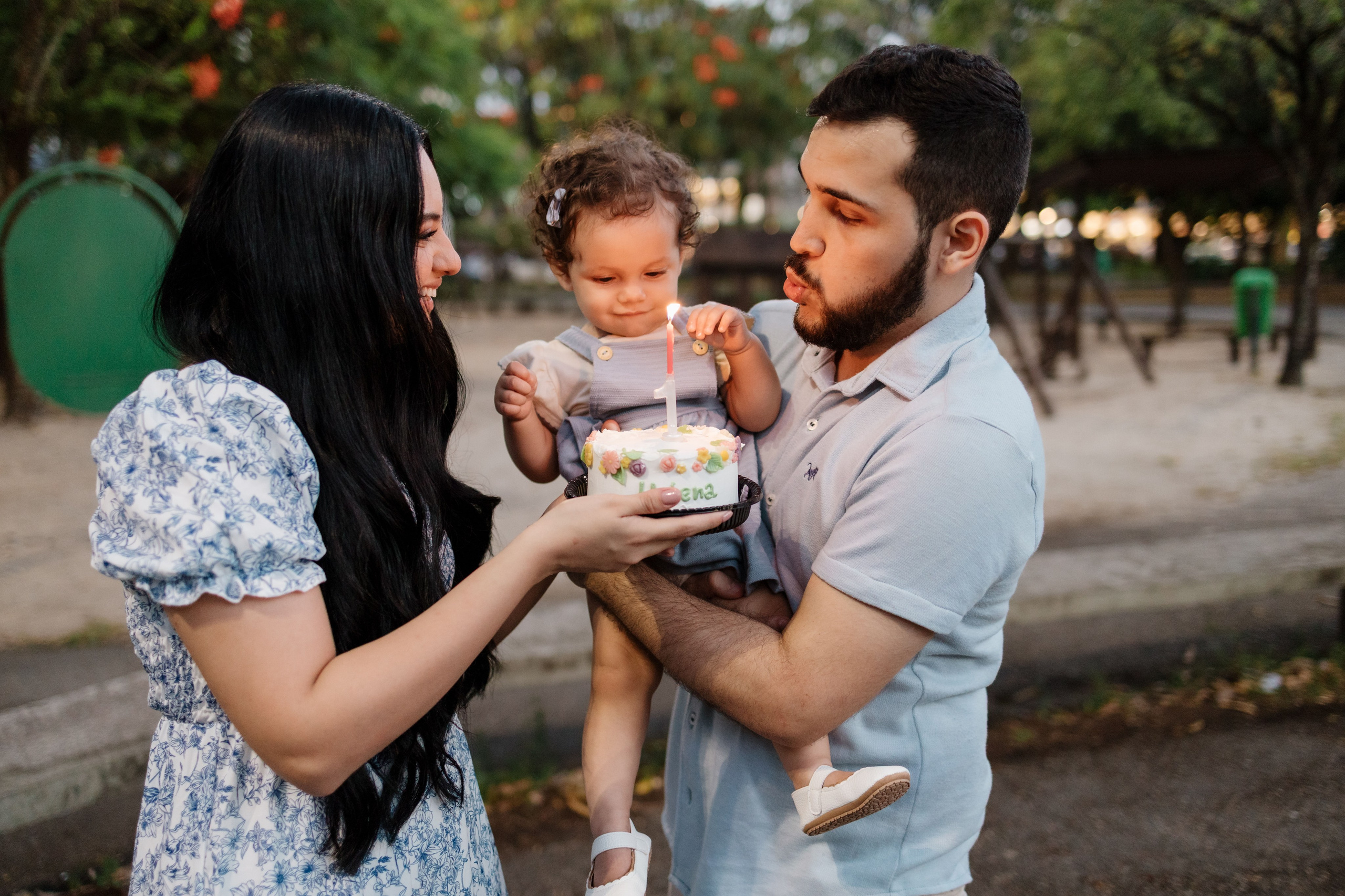 Família cantando parabéns de 1 ano em ensaio no parque