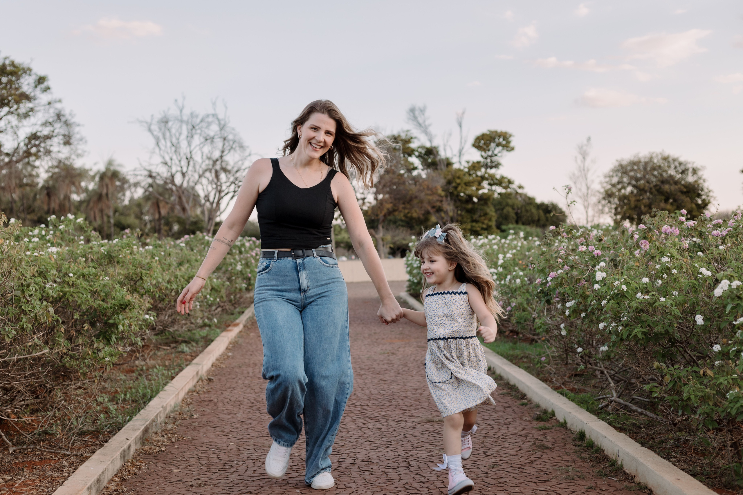 Mãe e filha correndo em ensaio família na praça dos cristais