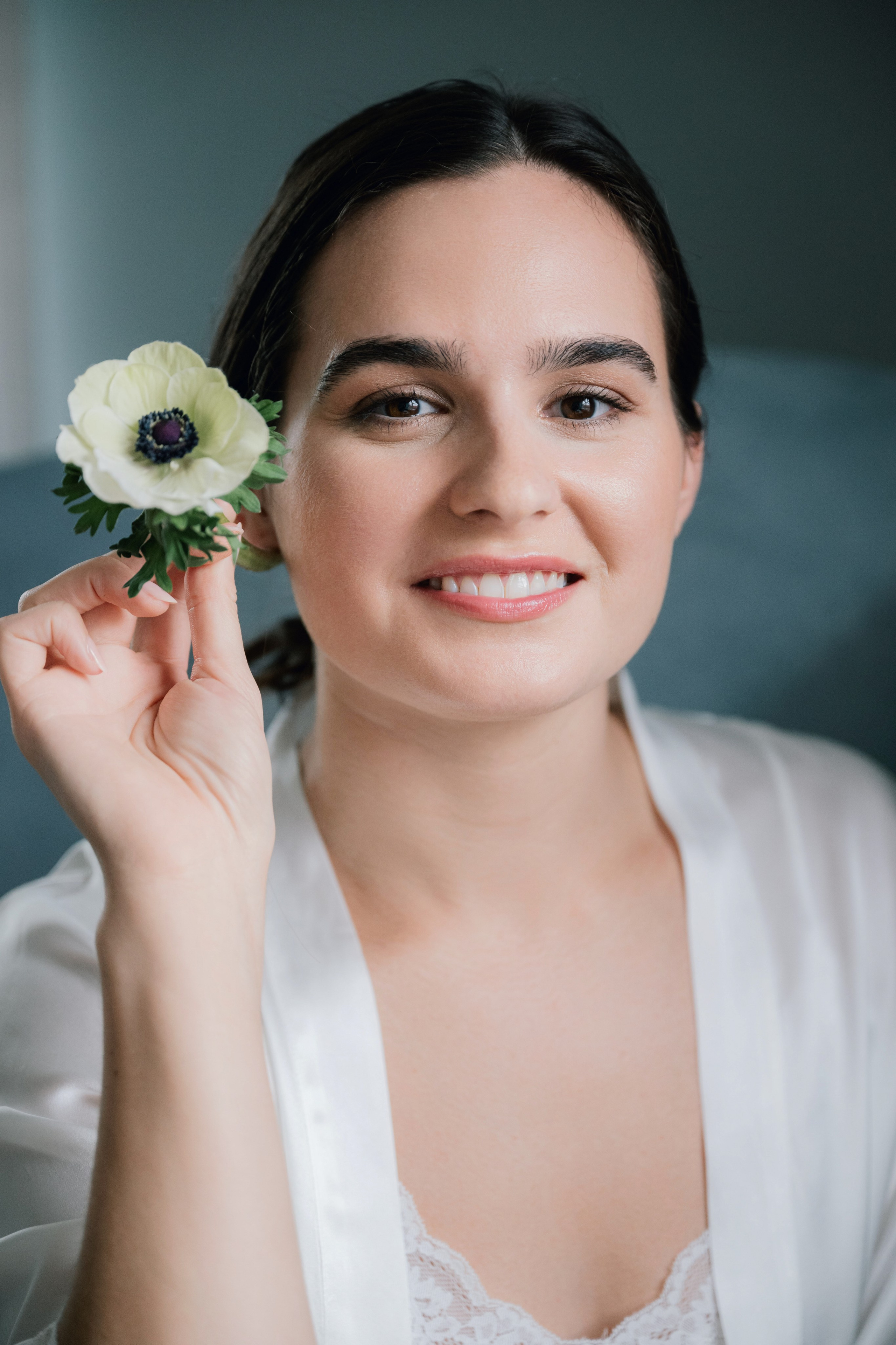 a woman in a white shirt holding a flower