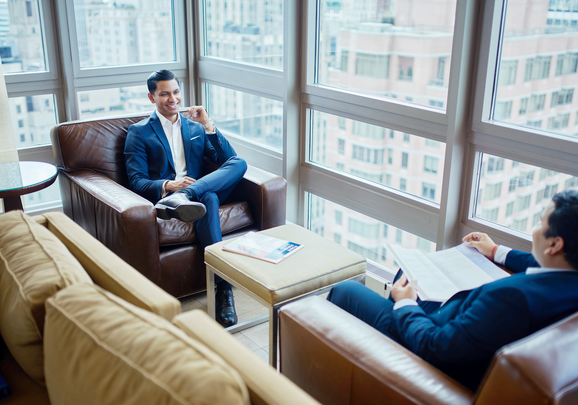 Corporate portrait of two CEO of Accern discussing  their business on top floor of skyscraper, with panoramic view of New York City.