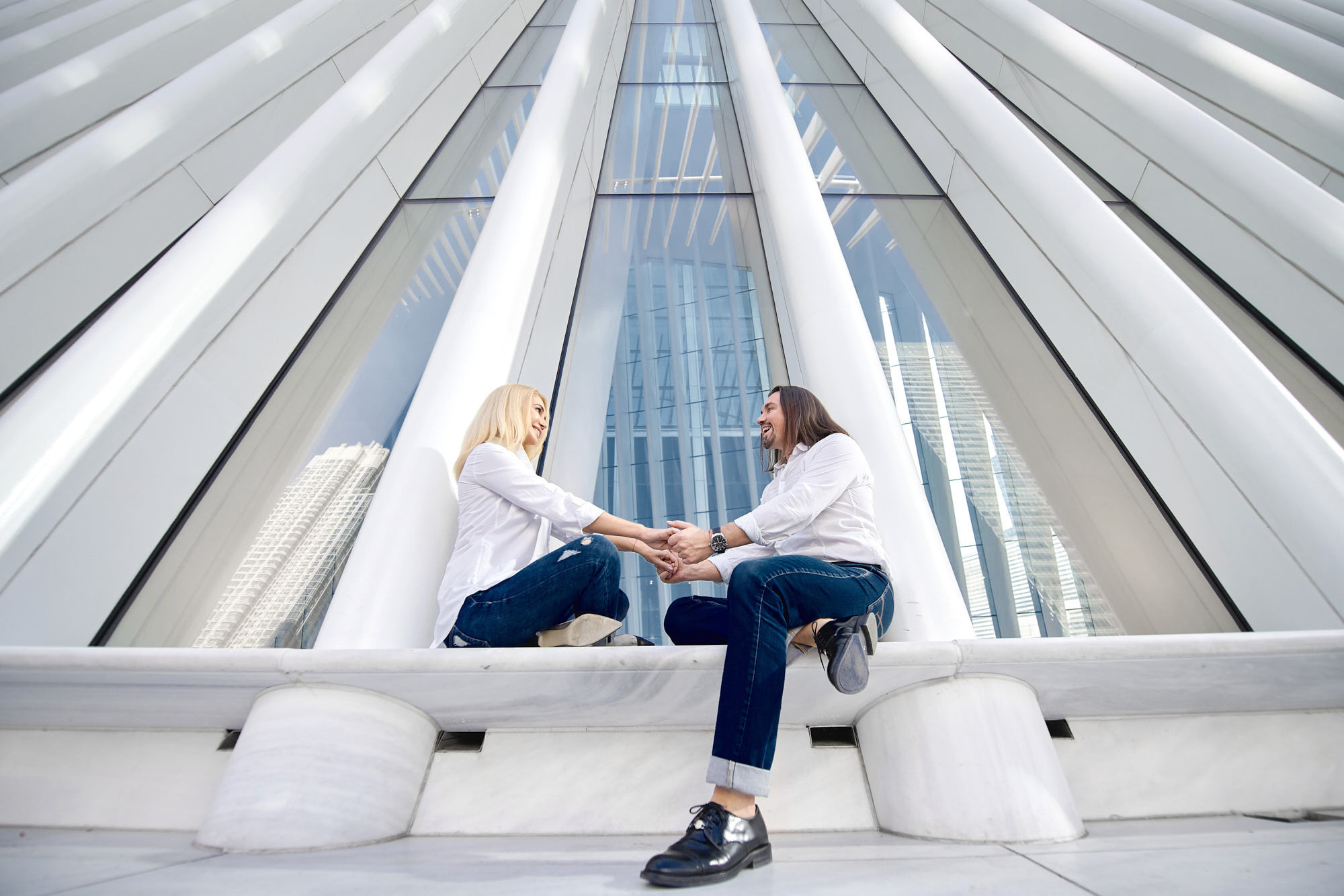 Urban engagement photos of Alex proposal at Oculus, World Trade Center, NY. Wide angle shot of th couple sitting on the border of the Oculus.