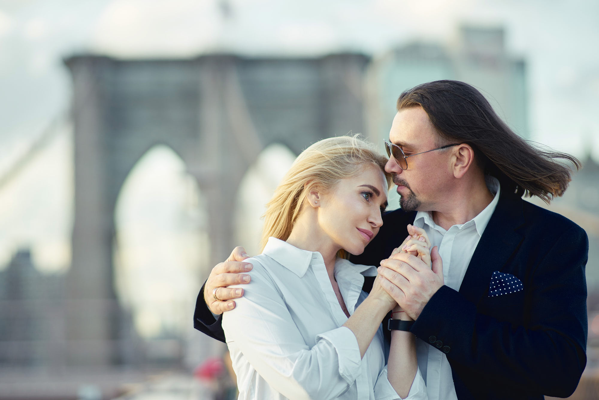 Couple photography of omantic Brooklyn Bridge sunset proposal with Manhattan skyline in the background.