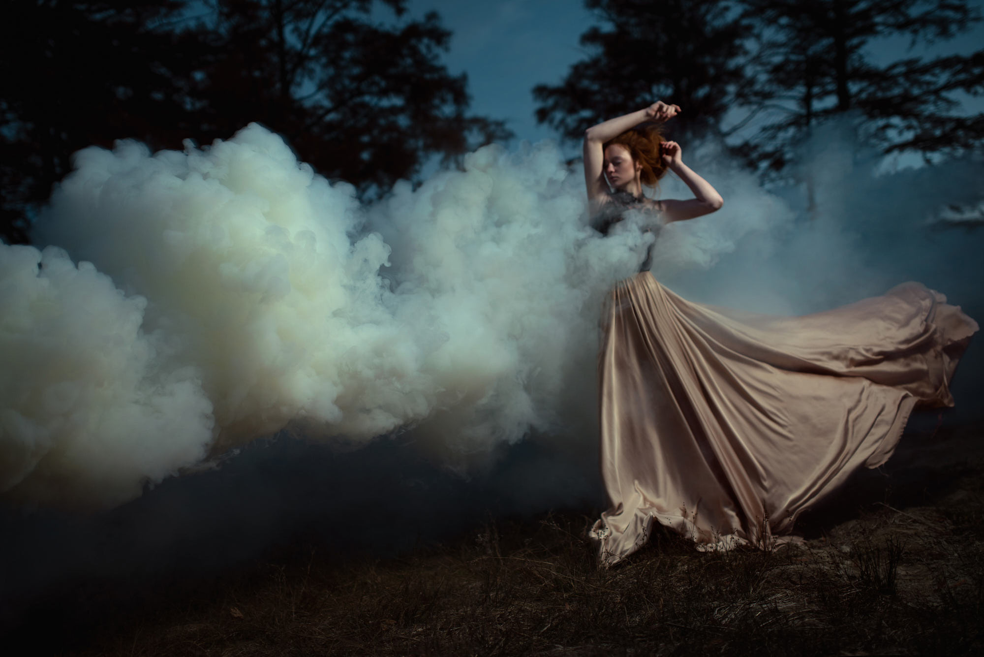 Red-haired girl in a brawn dress falling into cloud of smoke. Utopia editorial shot.