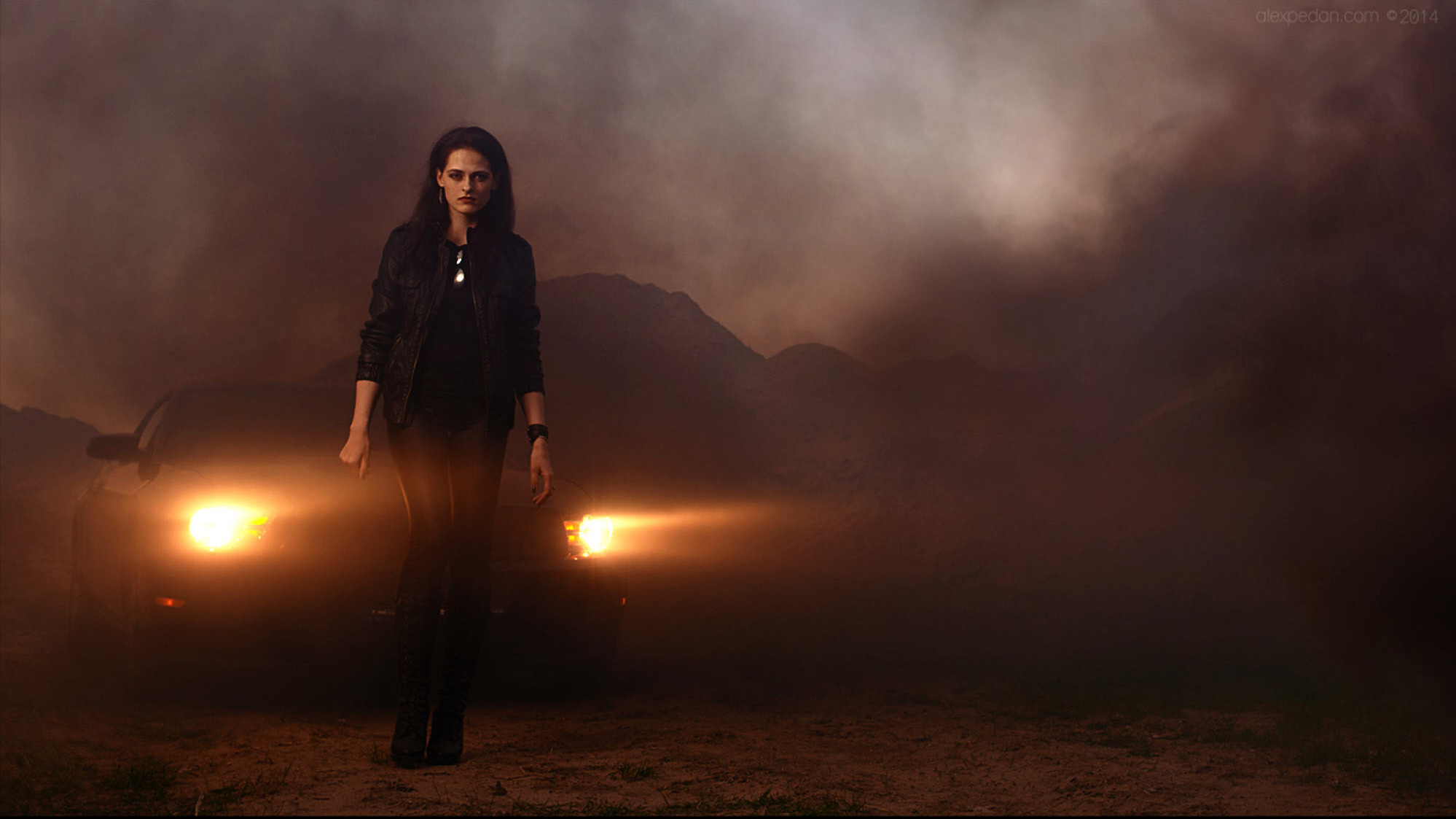 Pretty girl in leather black coat and pantscomming out of smoke and black Mustang. Model looks like Kristen Stewart from Twilight.