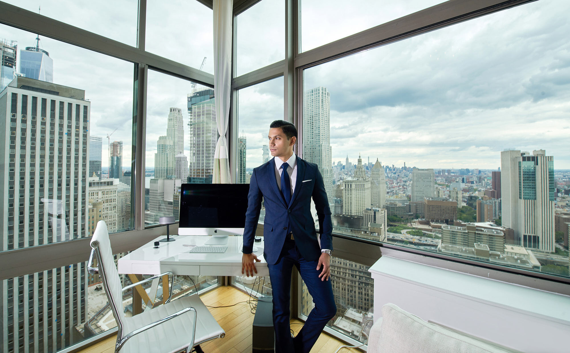 Portrait of Kumesh Aroomoogan, Co-founder and CEO at Accern, Forbes 30 Under 30. Top floor of skyscraper, with panoramic view of New York City.
