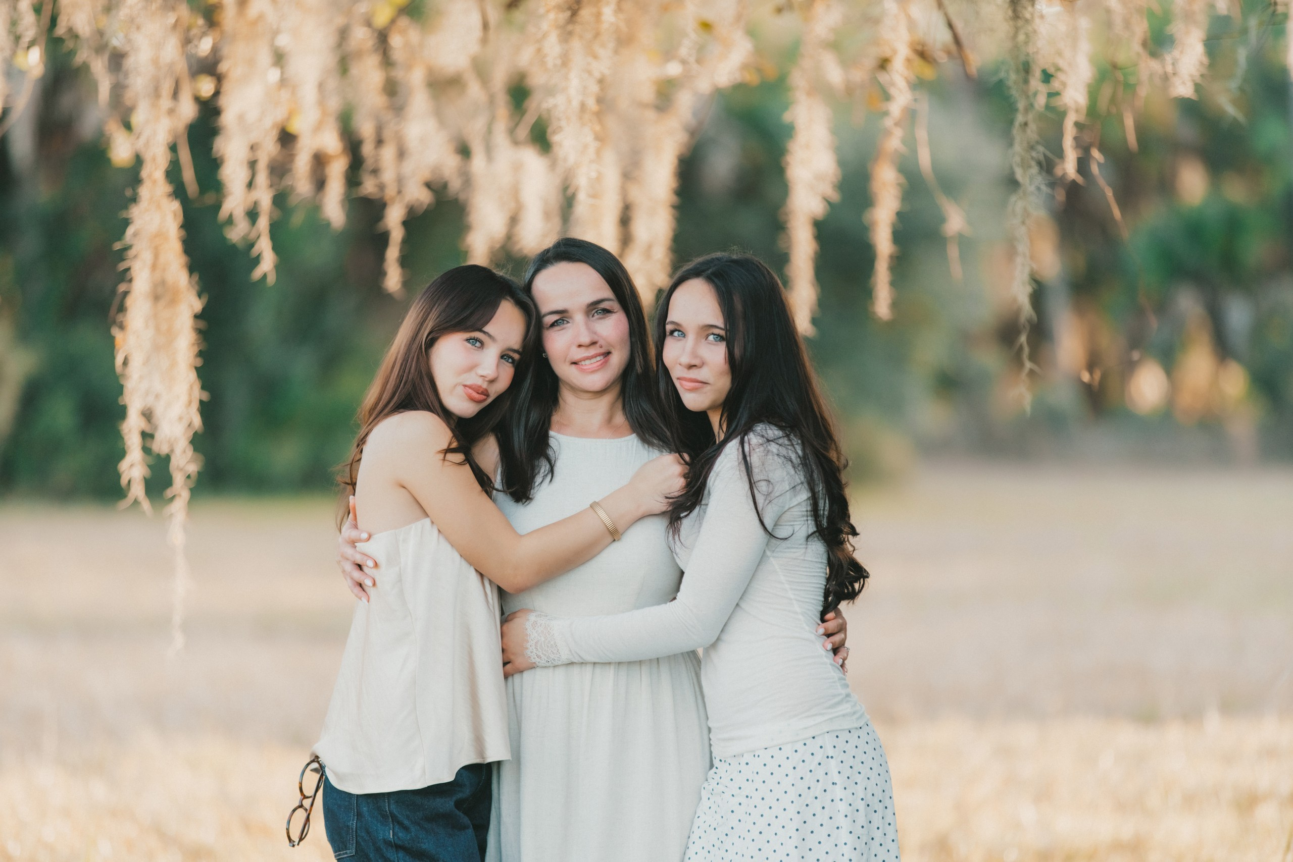 Mother hugging her two daughters, authentic family moments photography in Florida.