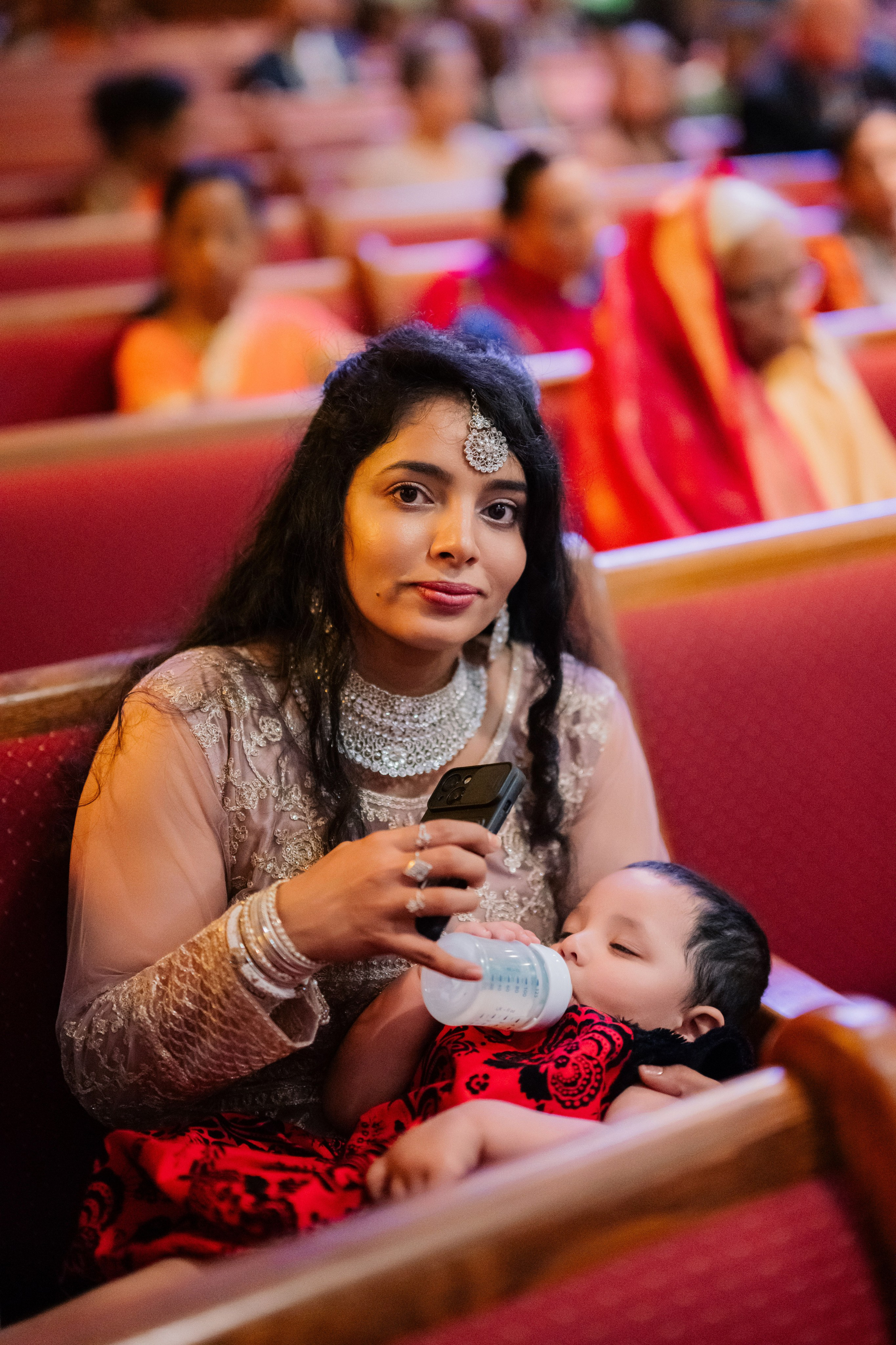 a woman sitting in a church with a baby
