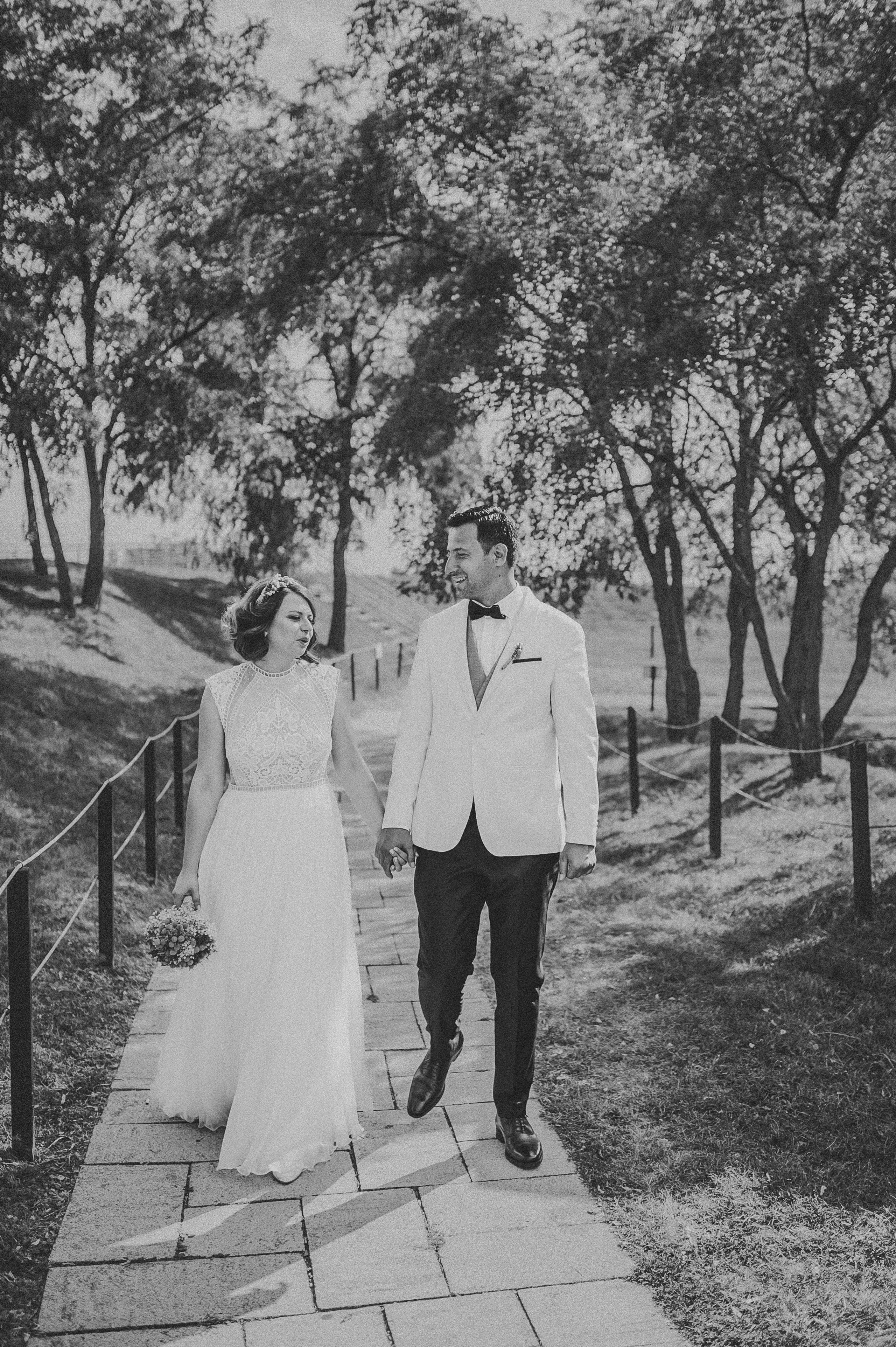 Sedinta foto alb-negru cu mirii tinandu-se de mana, in mijlocul unui peisaj natural.