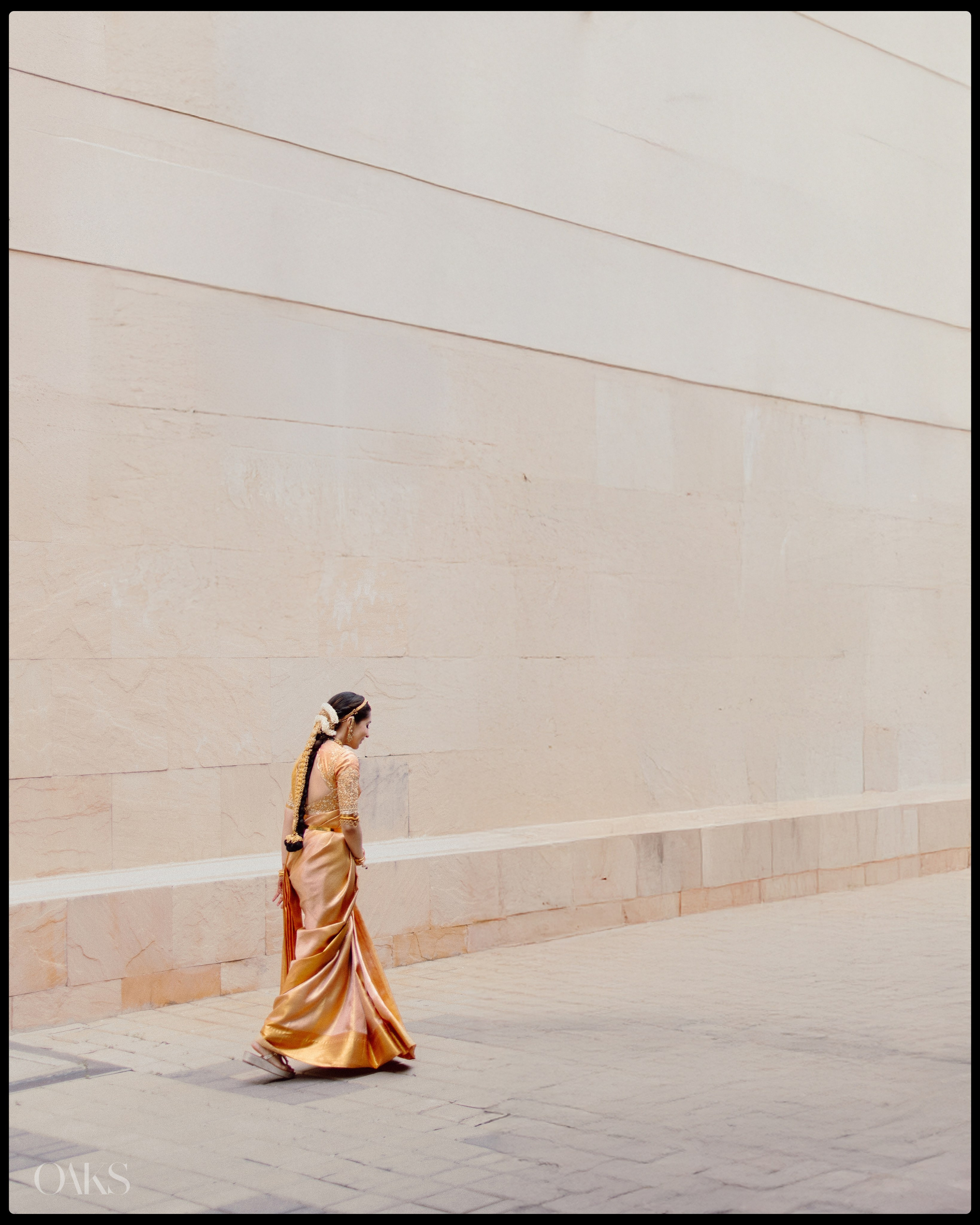 Minimalist bridal portrait with bride walking near textured wall