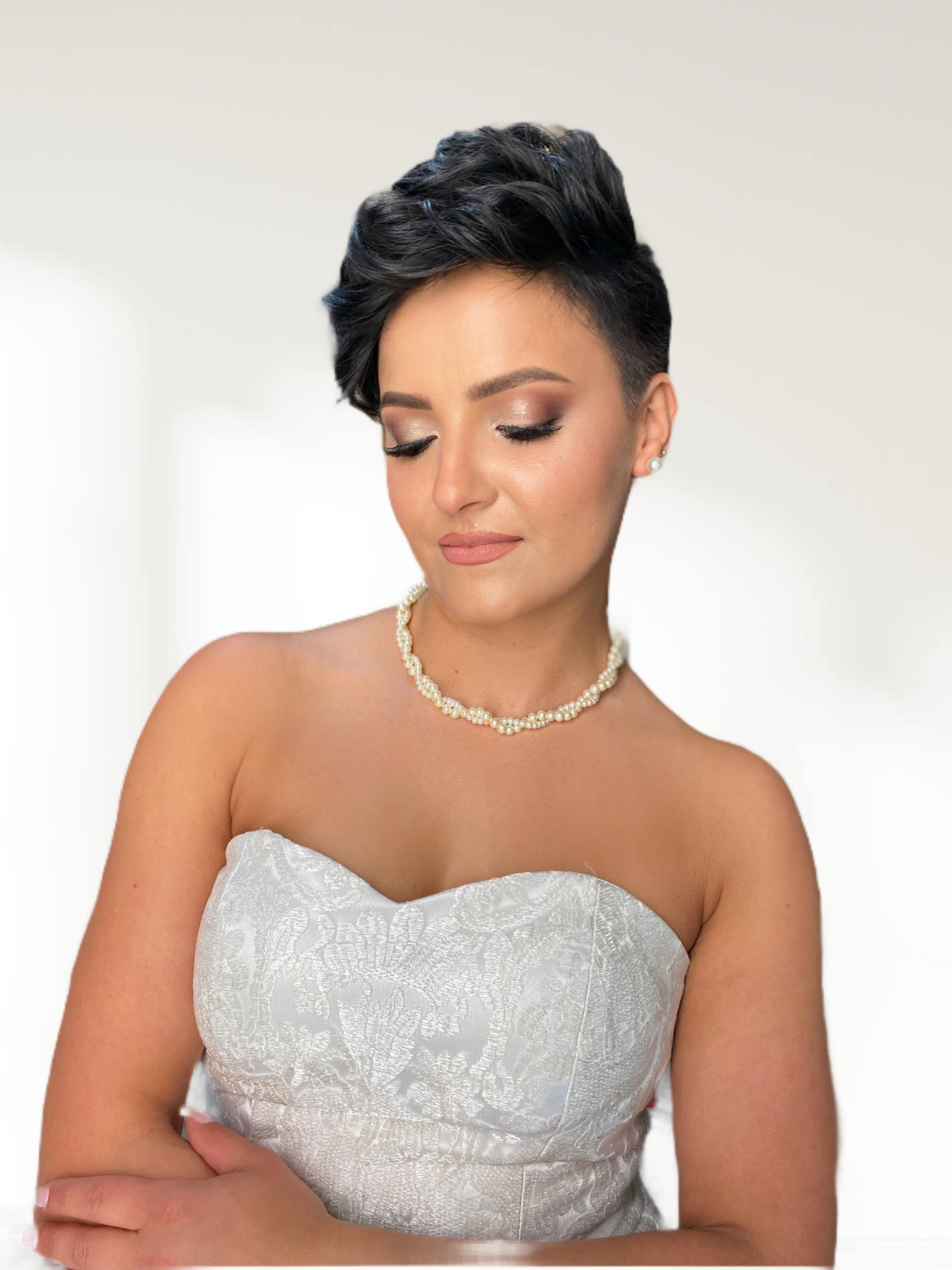 a bride with short dark hair curly hairstyle and natural wedding makeup on white background