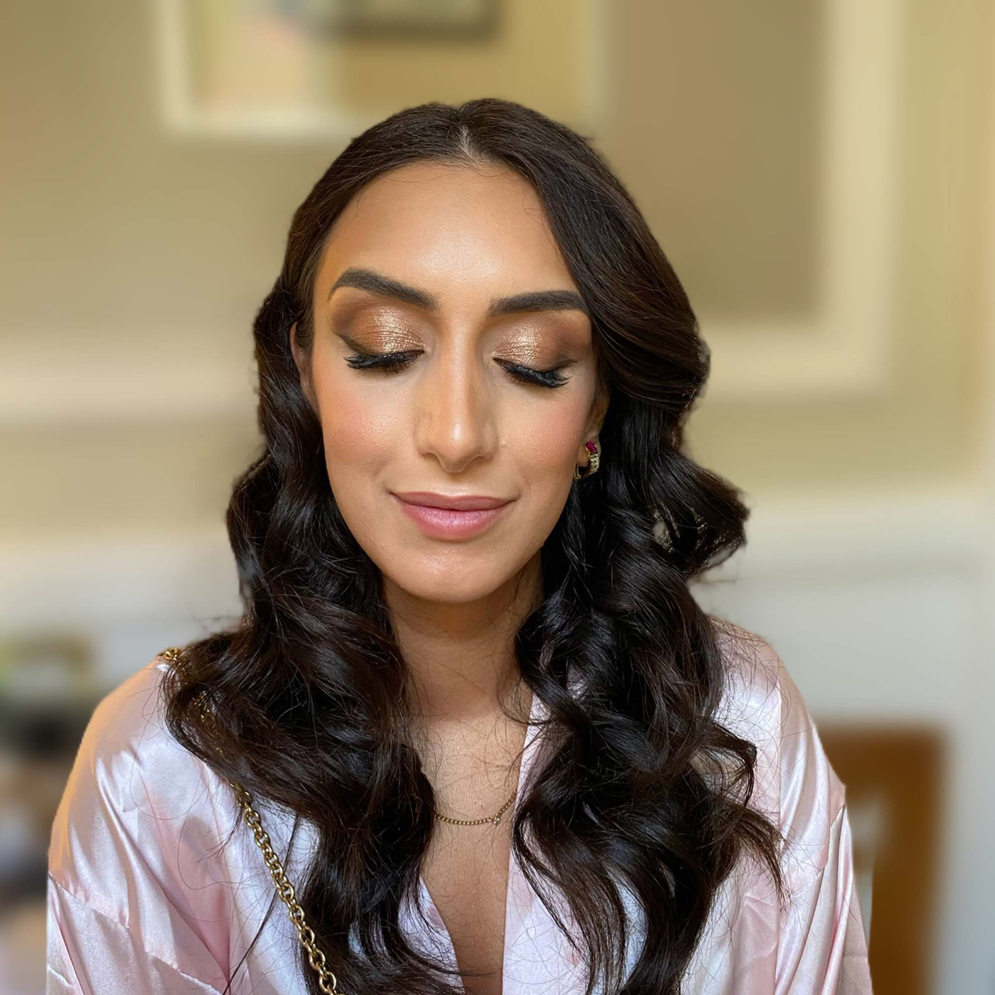 golden bronze makeup and wavy hairstyle on an iranian woman with strong face features for a special occasion in Rome