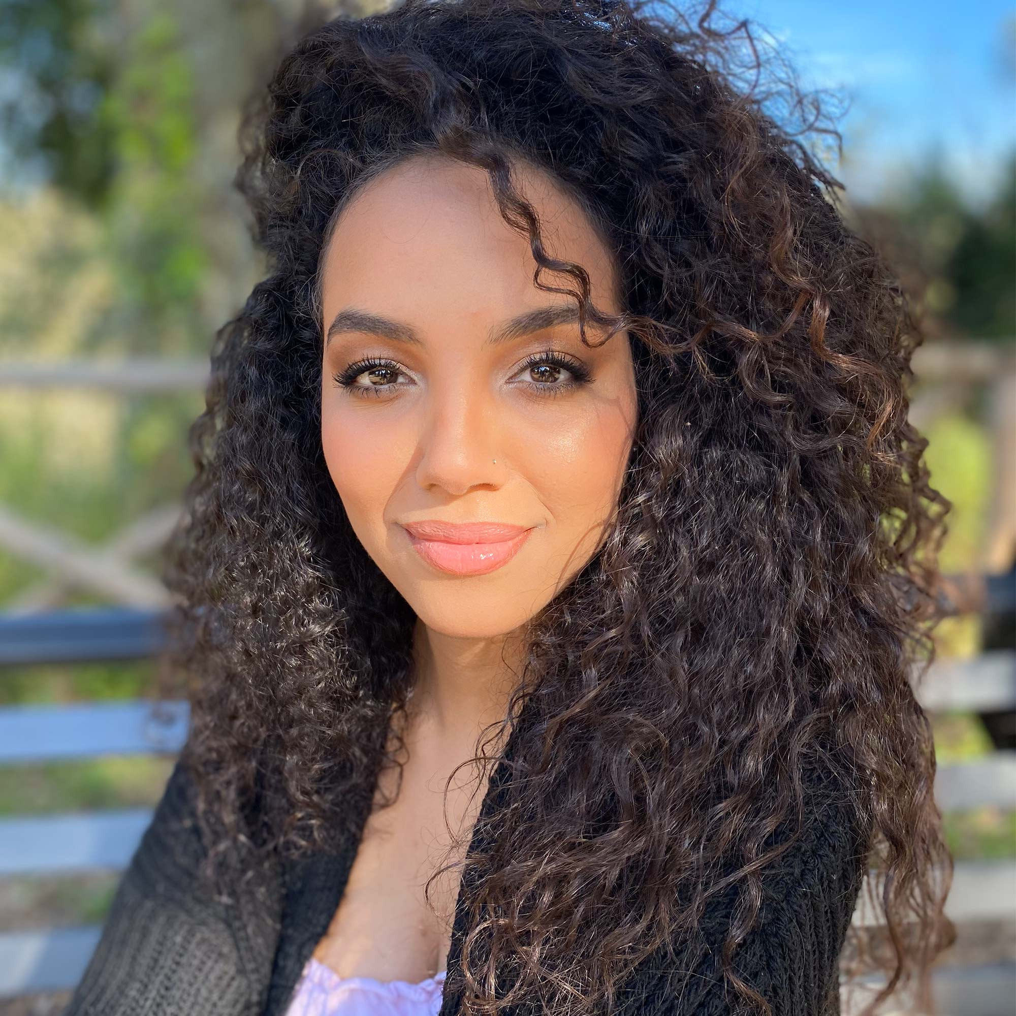arabic girl with a big curly hair and professional makeup in a park