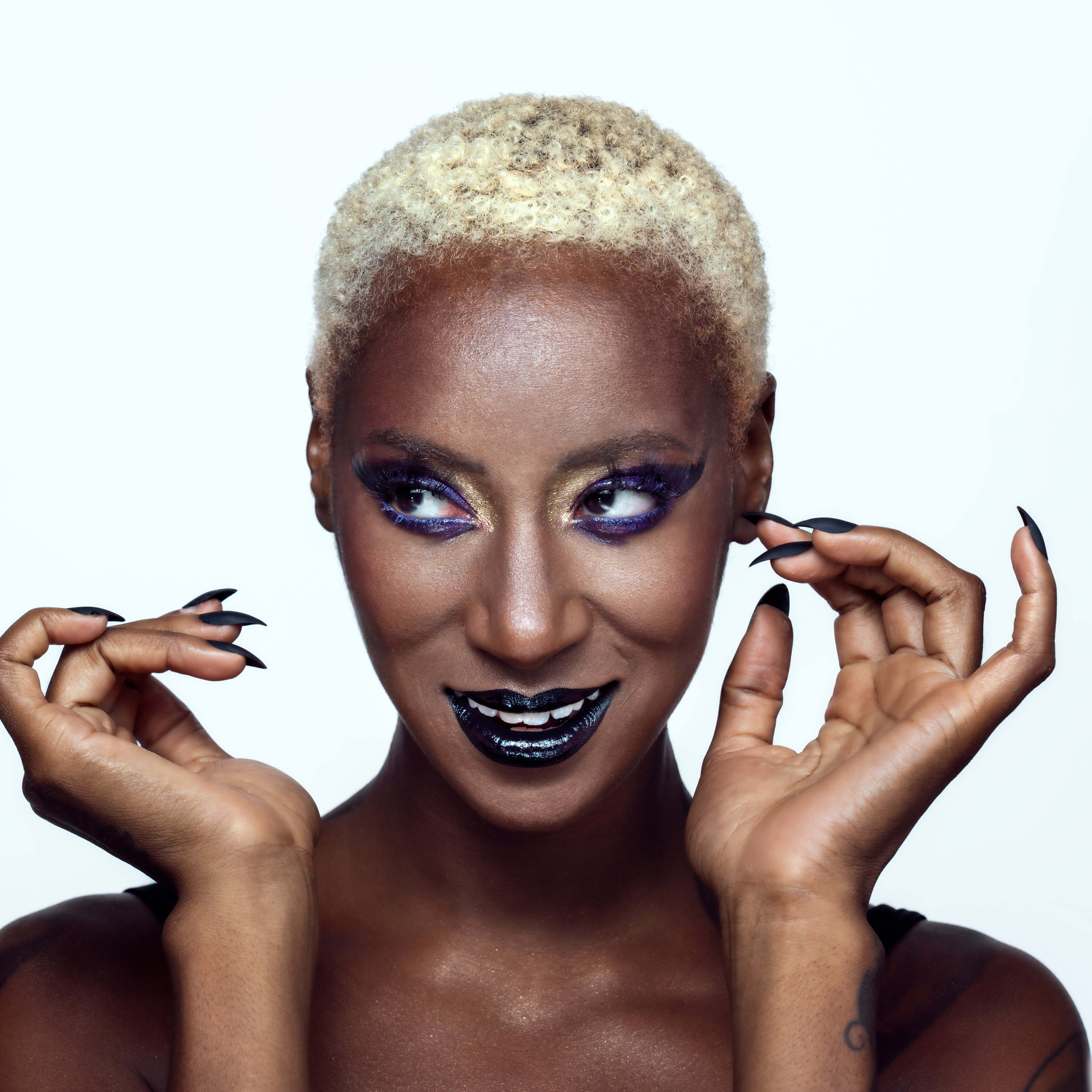 a dark skin woman with bright makeup and black glossy lips posing in a photostudio in rome