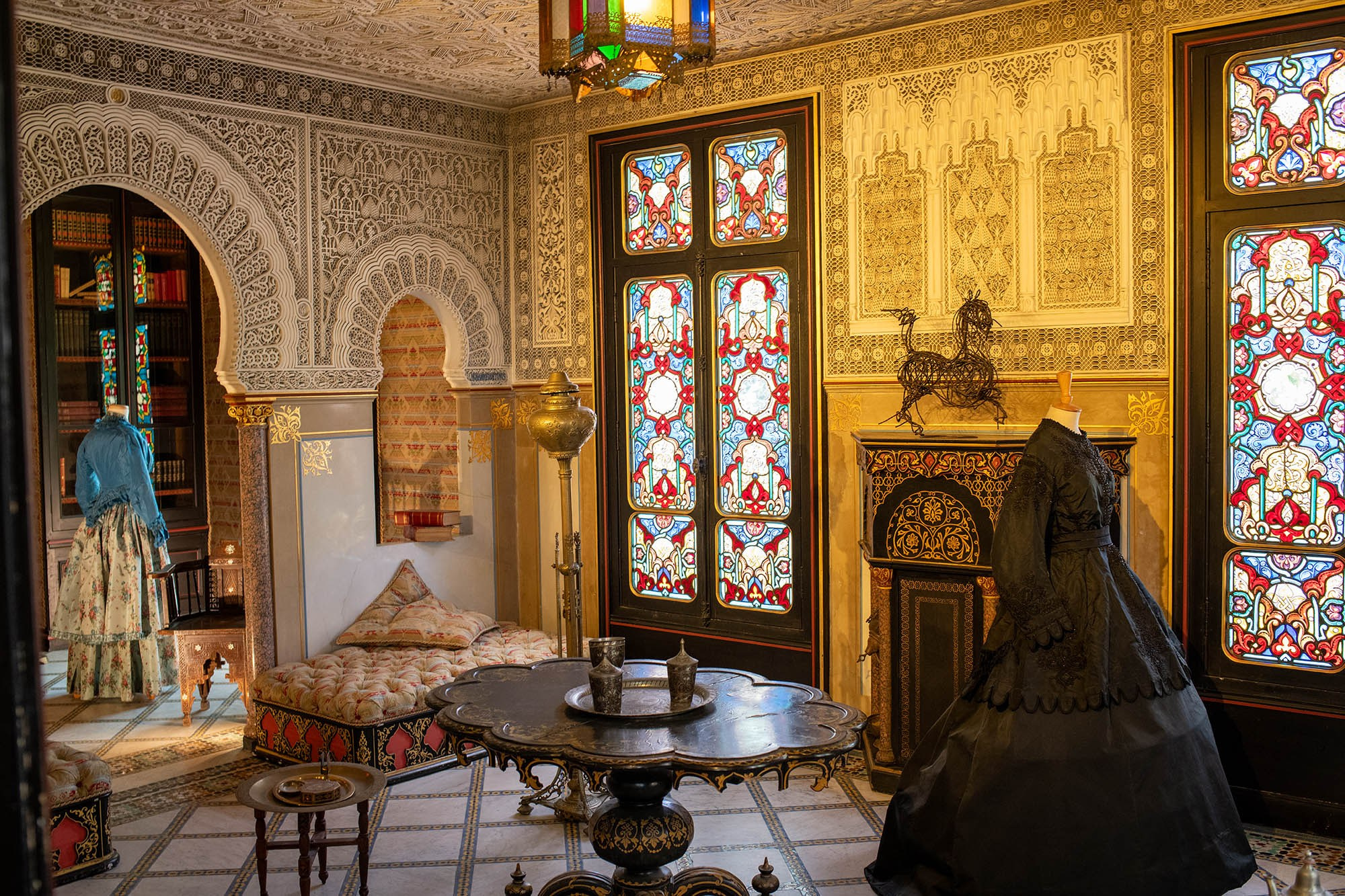 The Moorish Salon with stained-glass windows, ornate Moorish architecture, period costumes, and decorative fireplace at the Château de Monte-Cristo