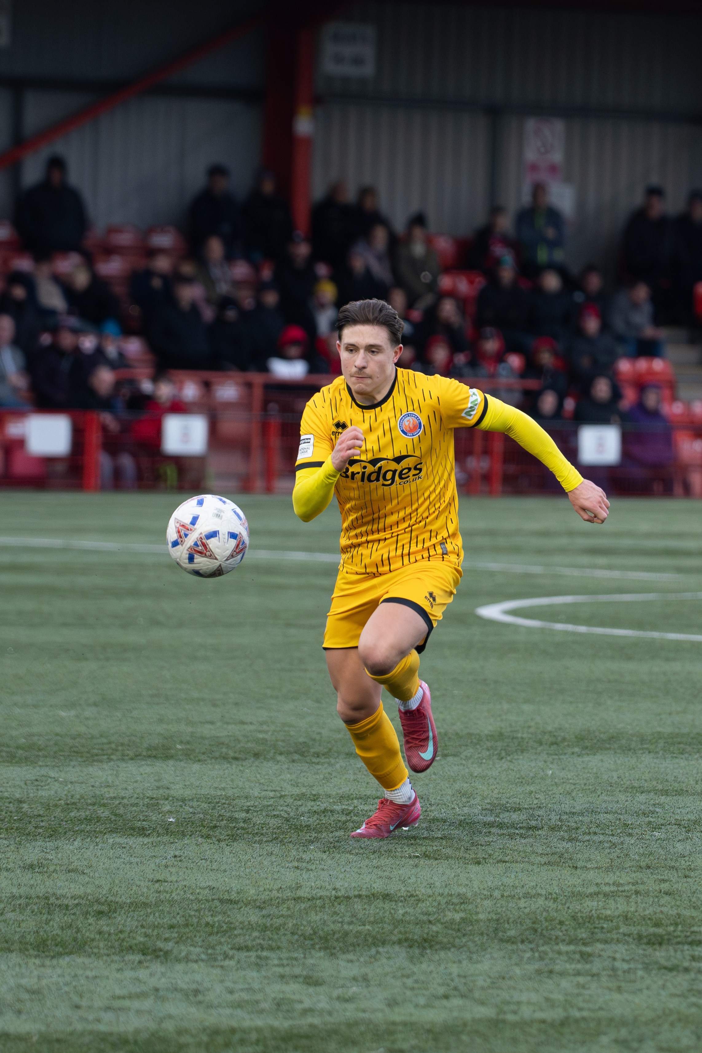 Tamworth, England — February 14, 2026: An Aldershot Town player runs onto the ball during the Enterprise National League match between Tamworth FC and Aldershot Town at The Lamb Ground. Photo: Jay Soundo